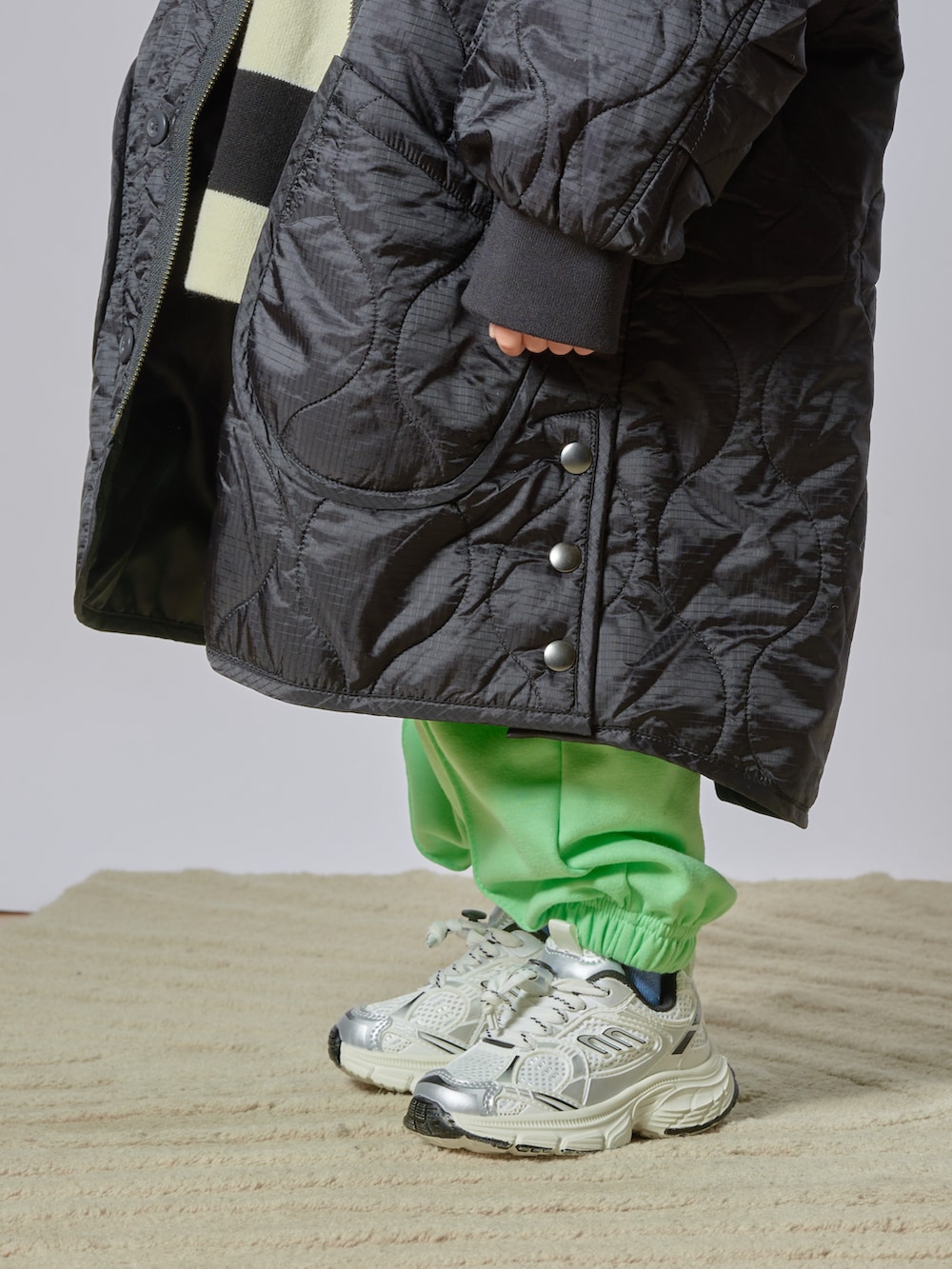 ブラック系のニット/セーター、ブラック系のダウンジャケット/コート、グリーン系のその他パンツを着用したキッズの冬コーディネートの3枚目の写真