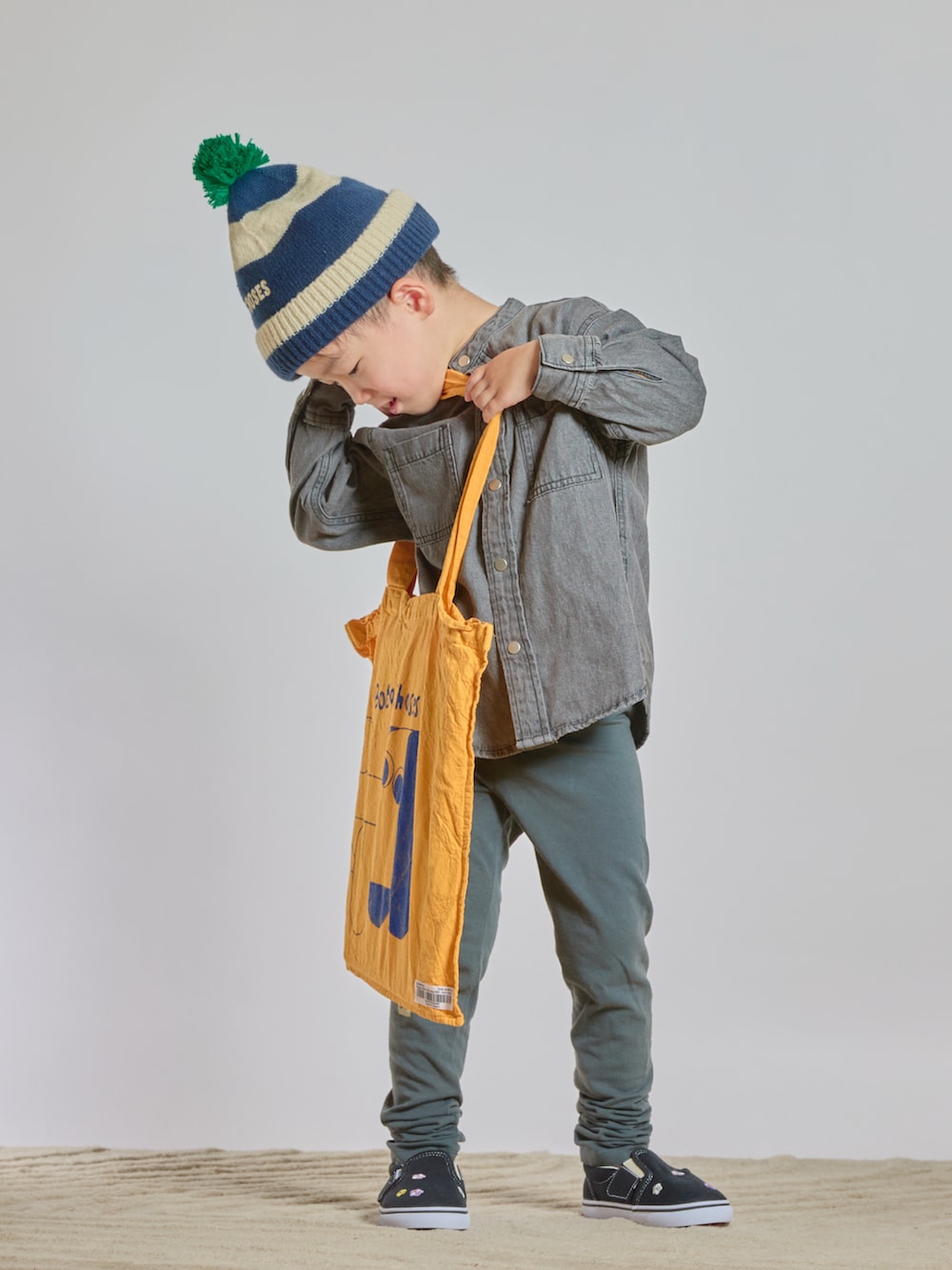 イエロー系のトートバッグ、ブラック系のシャツ/ブラウス、ブラック系のスリッポンを着用したキッズの秋コーディネートの4枚目の写真