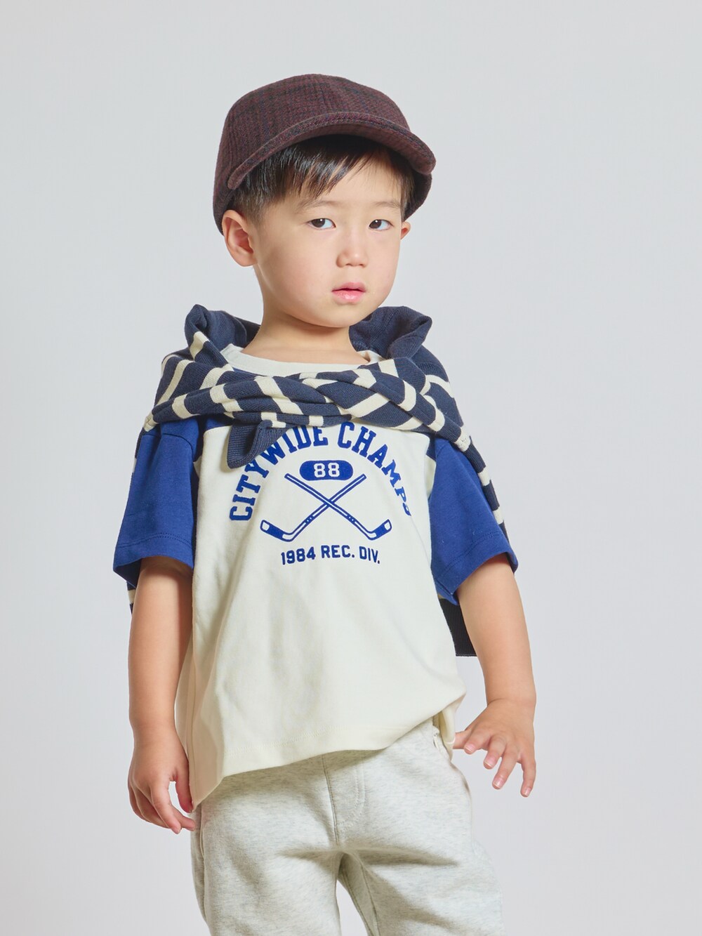 ホワイト系のTシャツ/カットソー、ブルー系のニット/セーター、ホワイト系のスウェットパンツを着用したキッズの秋コーディネートの2枚目の写真