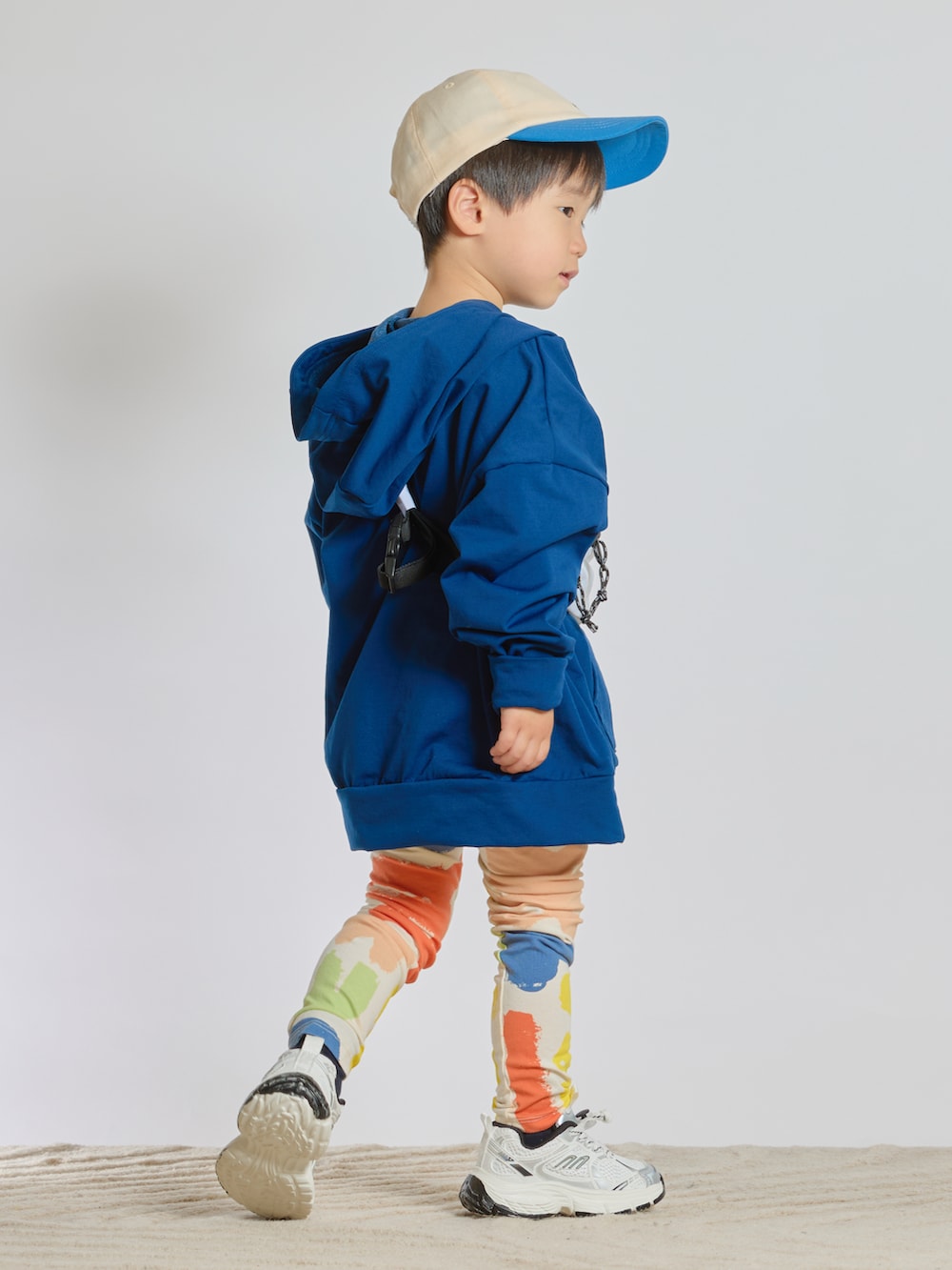 ブルー系のスウェット、ホワイト系のボディバッグ/ウエストポーチ、ホワイト系のスニーカーを着用したキッズの春コーディネートの4枚目の写真