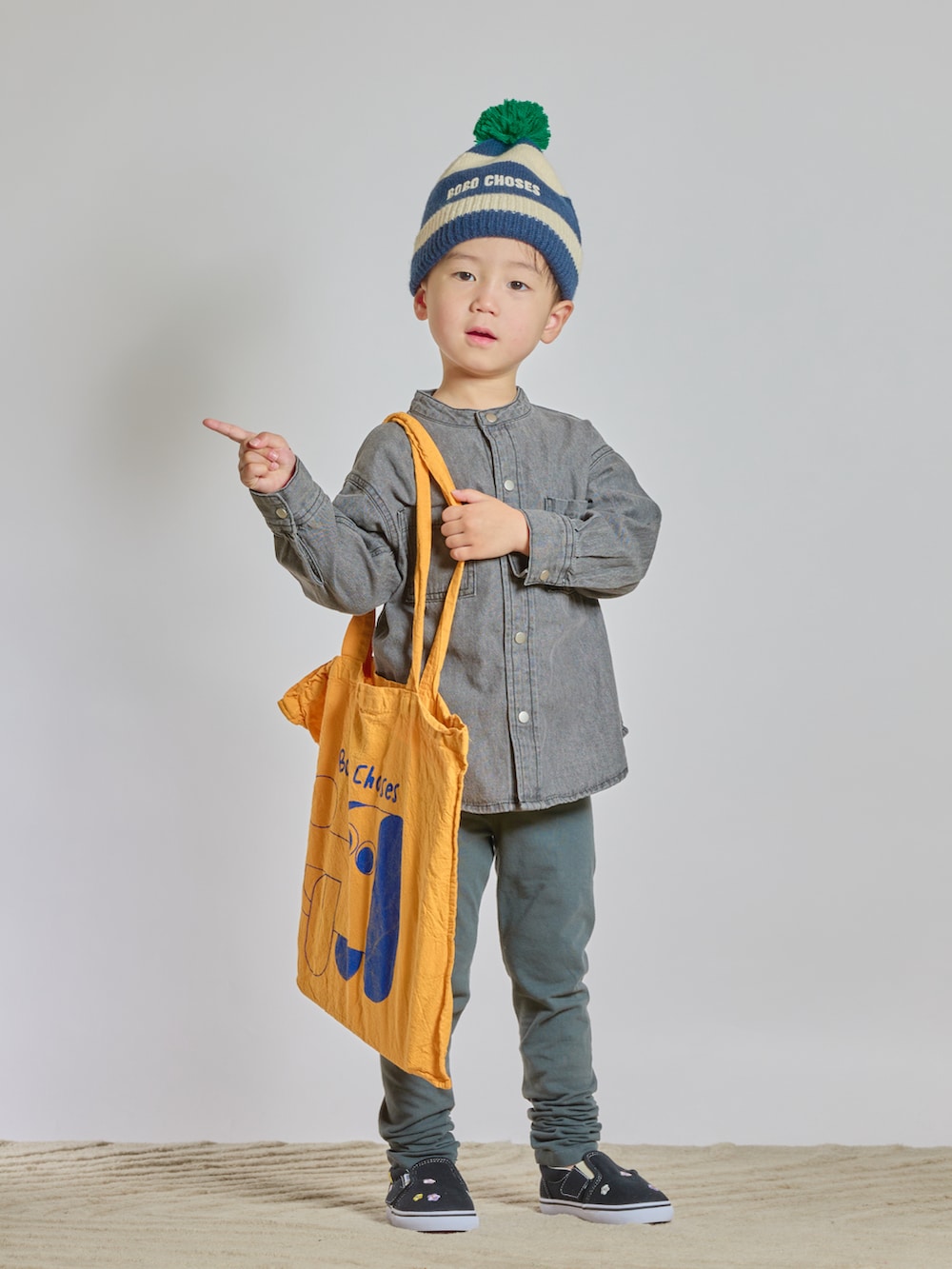 イエロー系のトートバッグ、ブラック系のシャツ/ブラウス、ブラック系のスリッポンを着用したキッズの秋コーディネートの5枚目の写真