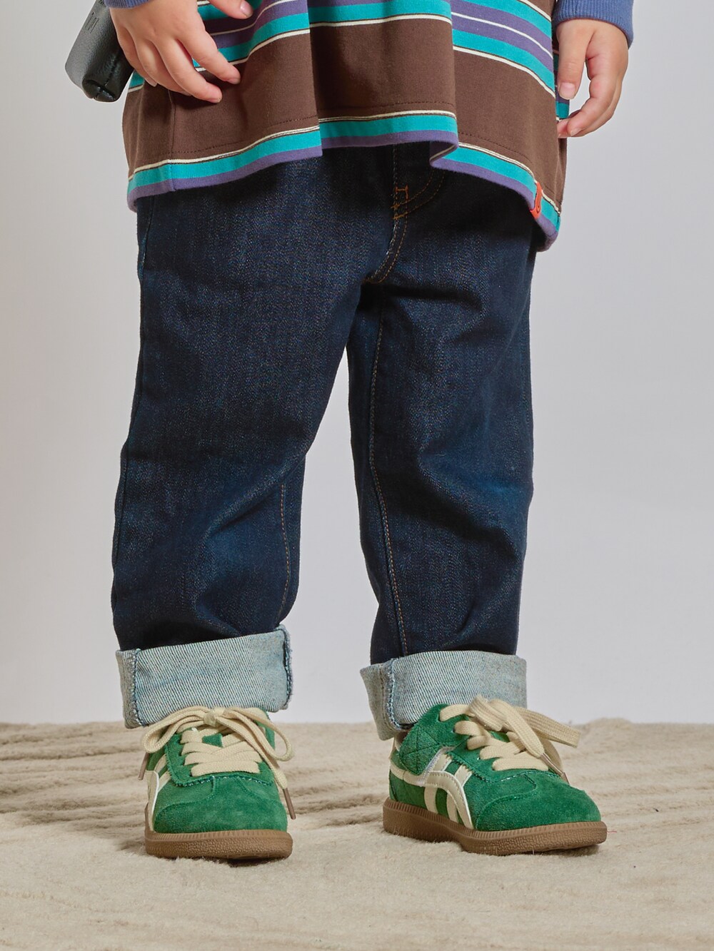 ブラウン系のTシャツ/カットソー、ブルー系のデニムパンツ、ブラック系のショルダーバッグを着用したキッズの秋コーディネートの5枚目の写真