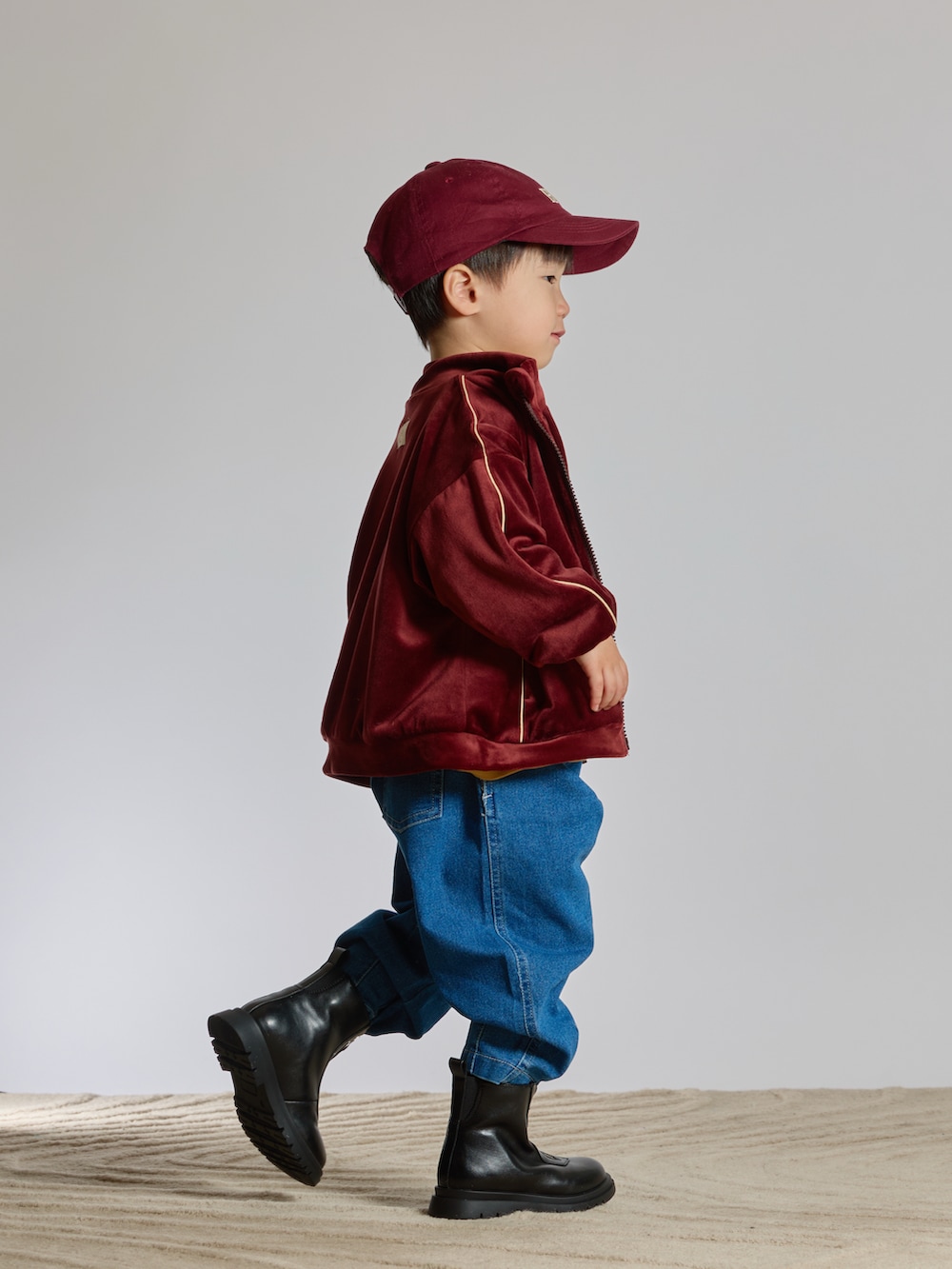 ブラウン系のジャージ、ブルー系のデニムパンツ、ブラック系のブーツを着用したキッズの春コーディネートの5枚目の写真