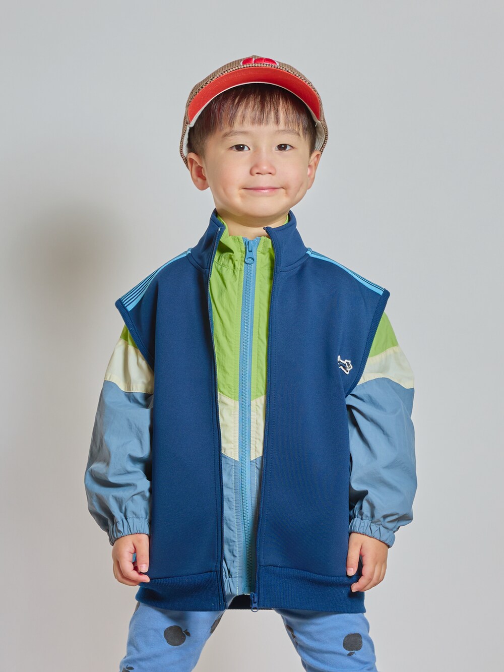 ブルー系のTシャツ/カットソー、イエロー系のナイロンジャケット、ブラック系のブーツを着用したキッズの秋コーディネートの2枚目の写真