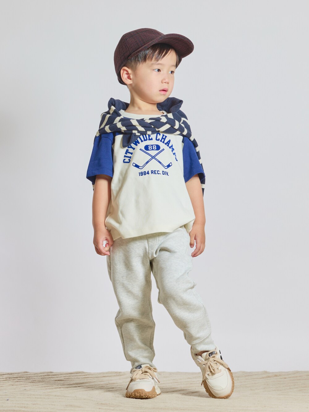 ホワイト系のTシャツ/カットソー、ブルー系のニット/セーター、ホワイト系のスウェットパンツを着用したキッズの秋コーディネートの4枚目の写真