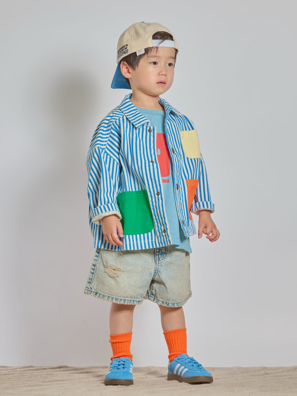 ブルー系のスニーカー、ブルー系のデニムパンツ、ブルー系のカバーオールを着用したキッズの春コーディネートの5枚目の写真