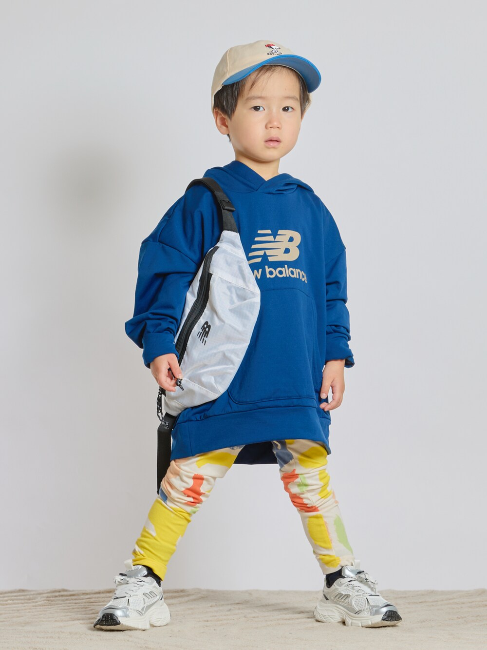 ブルー系のスウェット、ホワイト系のボディバッグ/ウエストポーチ、ホワイト系のスニーカーを着用したキッズの春コーディネートの5枚目の写真