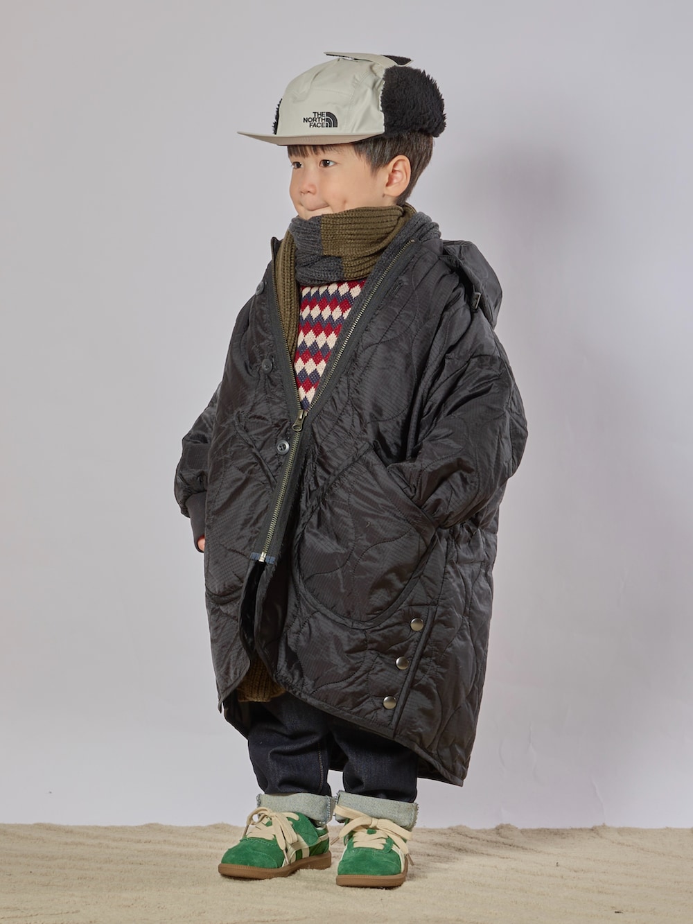 ブラック系のダウンジャケット/コート、ブルー系のスウェット、ブルー系のデニムパンツを着用したキッズの秋コーディネートの2枚目の写真