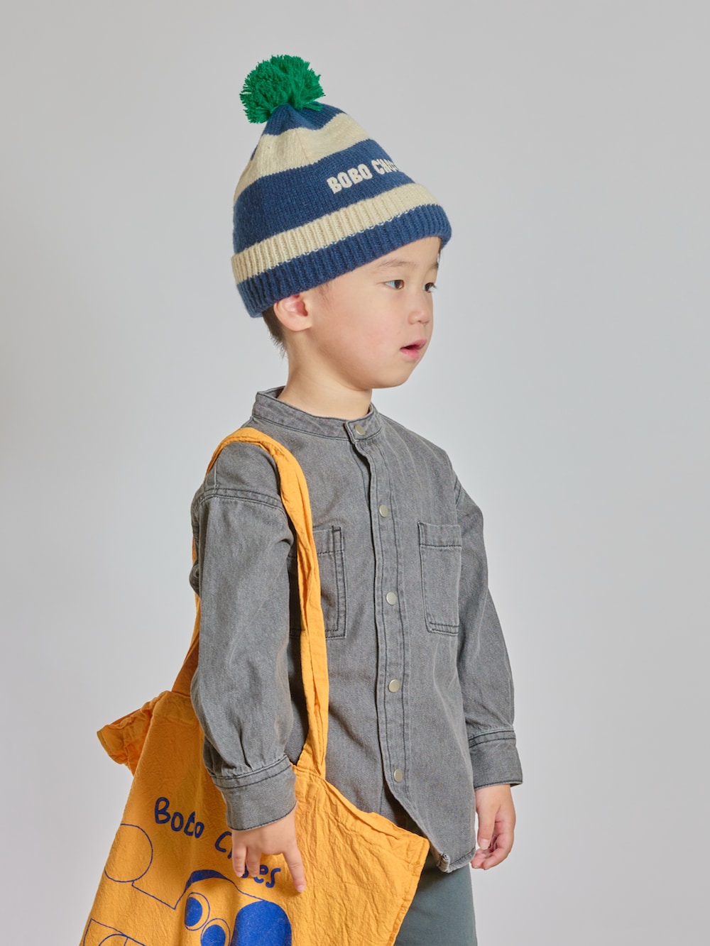 イエロー系のトートバッグ、ブラック系のシャツ/ブラウス、ブラック系のスリッポンを着用したキッズの秋コーディネートの3枚目の写真