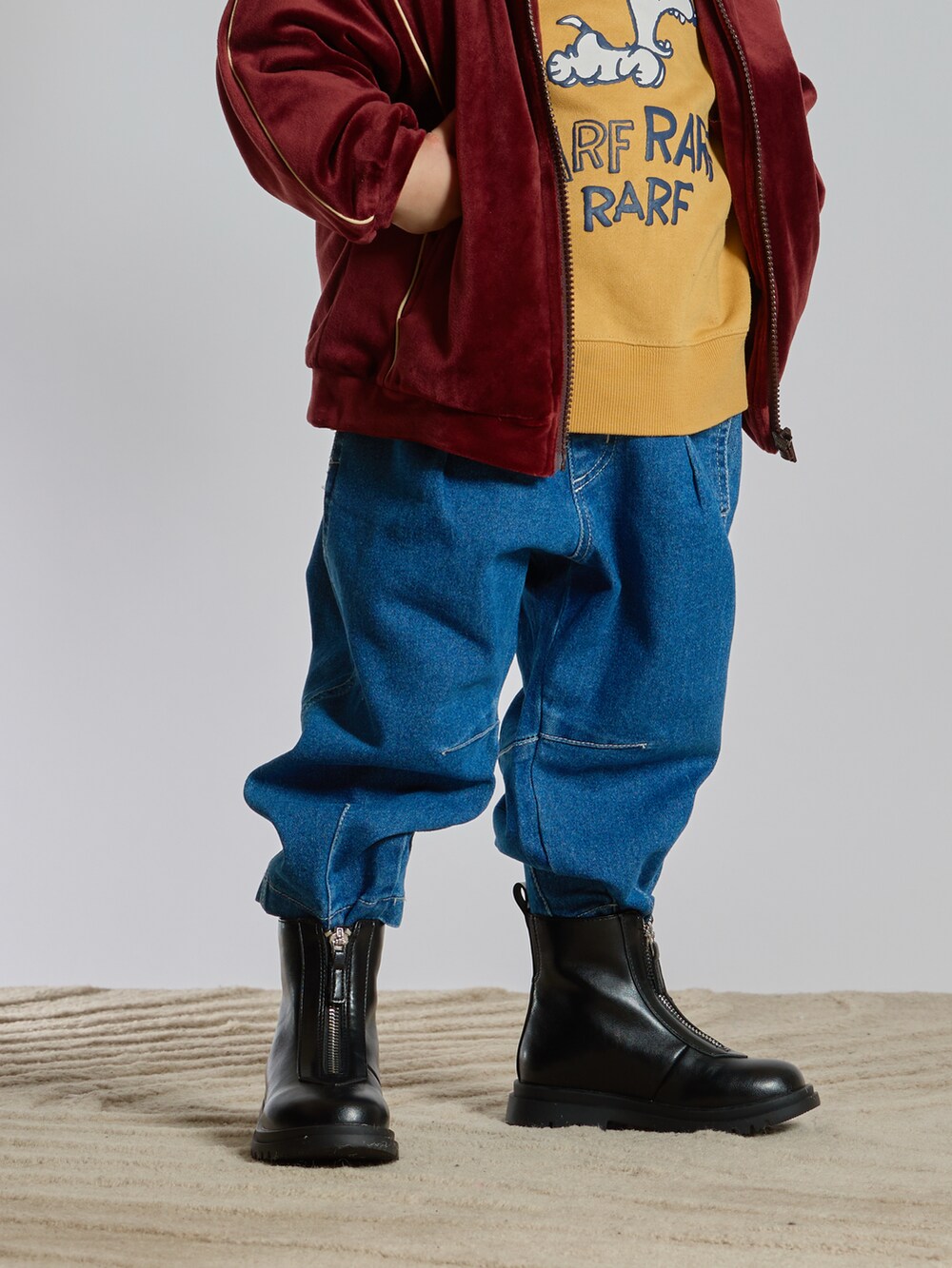 ブラウン系のジャージ、ブルー系のデニムパンツ、ブラック系のブーツを着用したキッズの春コーディネートの4枚目の写真