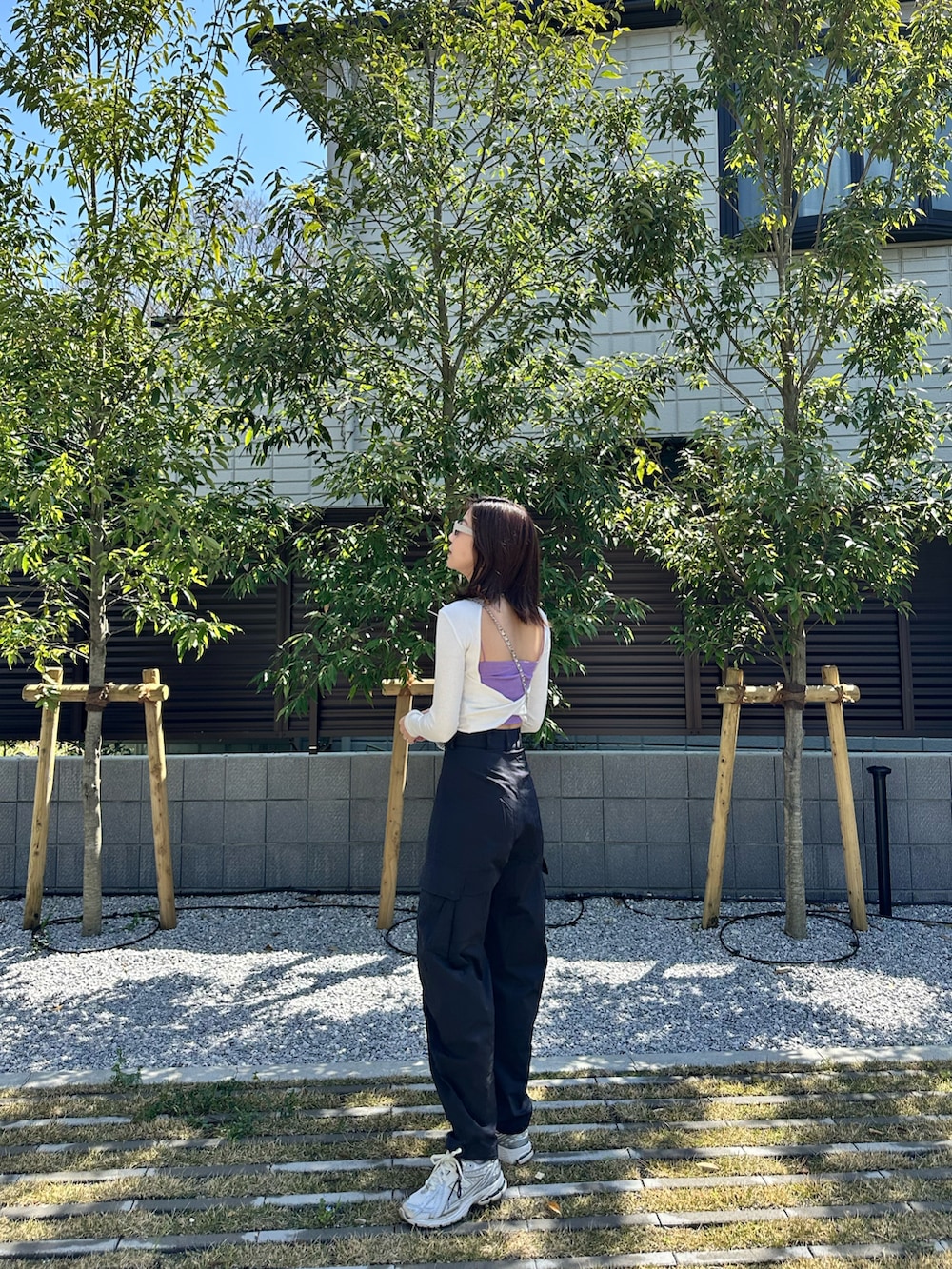 ブラック系のカーゴパンツ、ホワイト系のTシャツ/カットソー、シルバー系のスニーカーを着用したレディースの春コーディネートの2枚目の写真