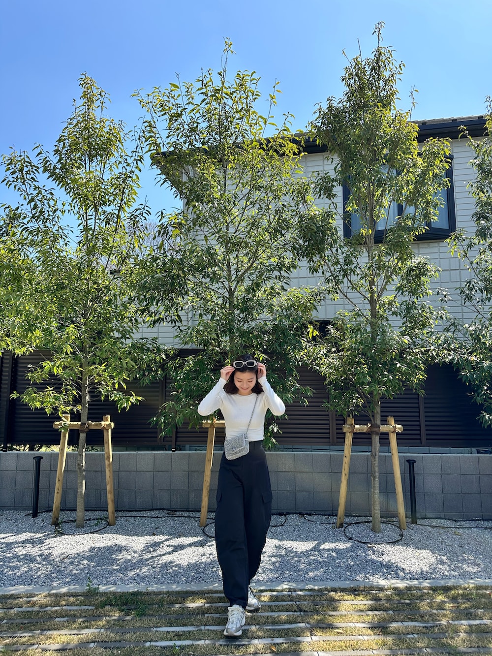 ブラック系のカーゴパンツ、ホワイト系のTシャツ/カットソー、シルバー系のスニーカーを着用したレディースの春コーディネートの3枚目の写真