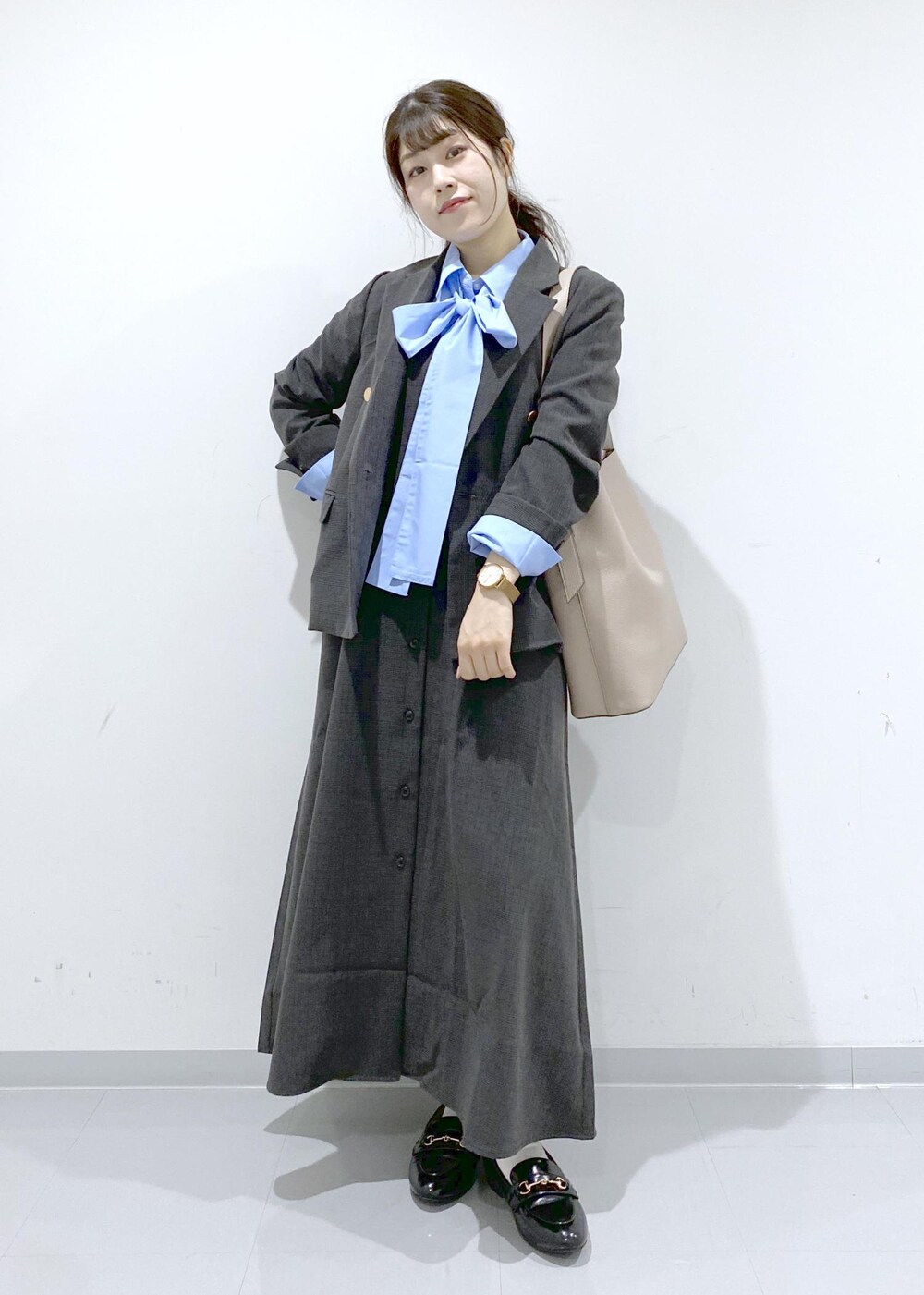 ベージュ系のショルダーバッグ、ブラック系のジャンパースカート、ブラック系のテーラードジャケットを着用したレディースの秋コーディネートの7枚目の写真