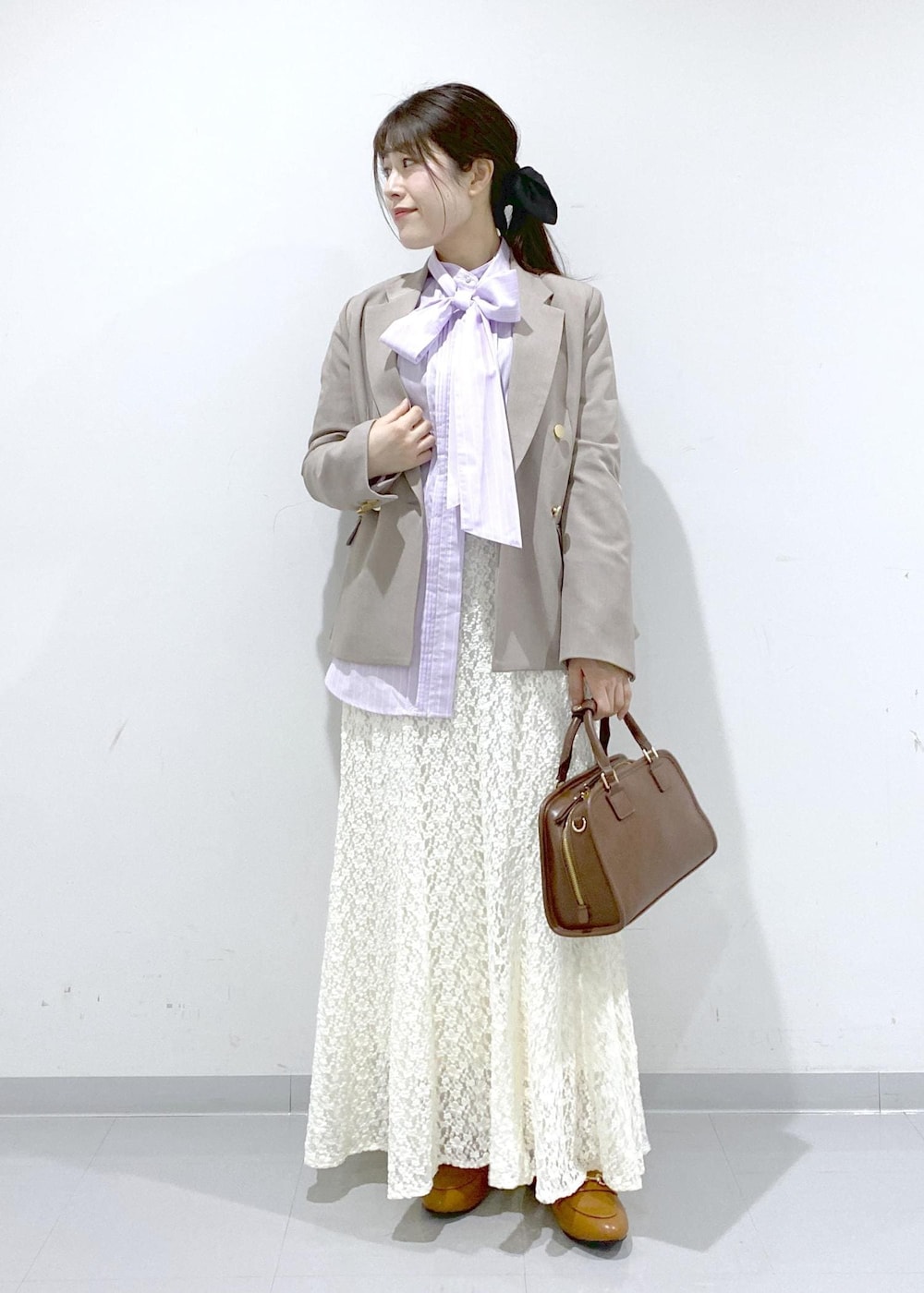 イエロー系のローファー、ブラウン系のボストンバッグ、ベージュ系のテーラードジャケットを着用したレディースの冬コーディネートの8枚目の写真