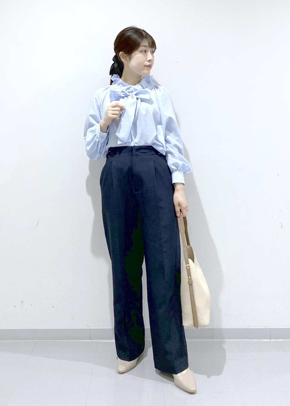 ベージュ系のパンプス、ホワイト系のショルダーバッグ、ブルー系のシャツ/ブラウスを着用したレディースの冬コーディネートの3枚目の写真