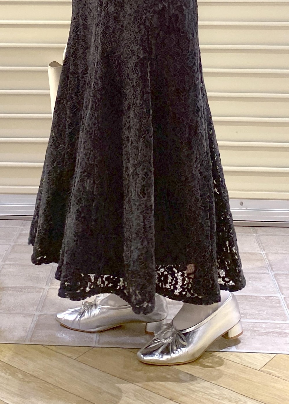 シルバー系のパンプス、ブラック系のパーカー、グレー系のスカートを着用したレディースの秋コーディネートの9枚目の写真