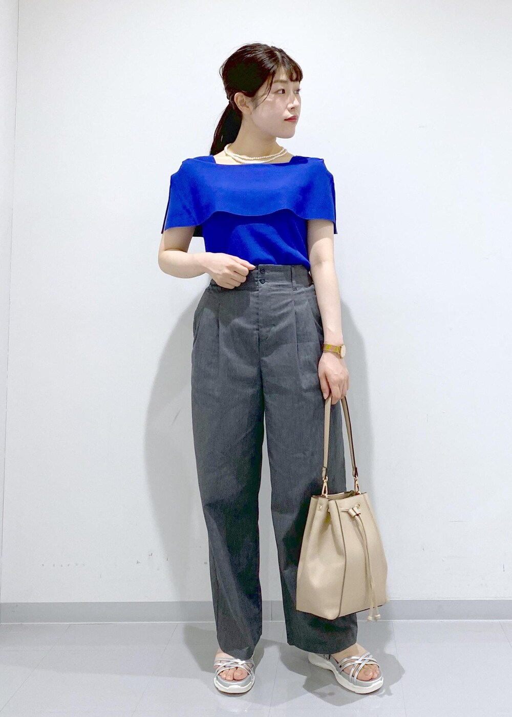 ベージュ系のショルダーバッグ、シルバー系のサンダル、グレー系のチノパンツを着用したレディースの夏コーディネートの8枚目の写真