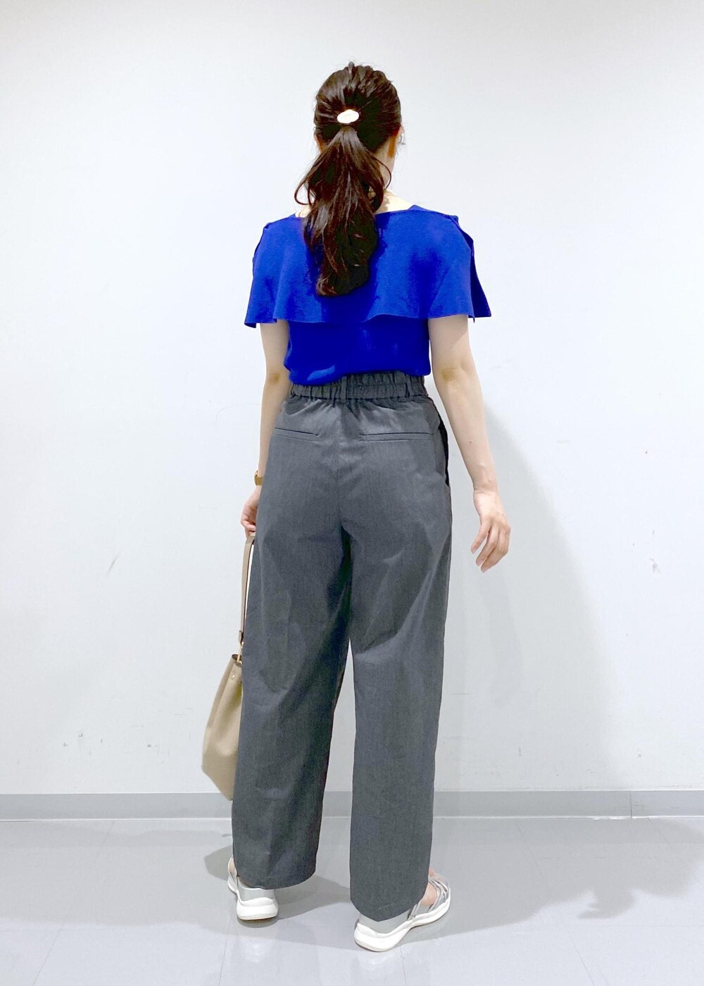 ベージュ系のショルダーバッグ、シルバー系のサンダル、グレー系のチノパンツを着用したレディースの夏コーディネートの6枚目の写真