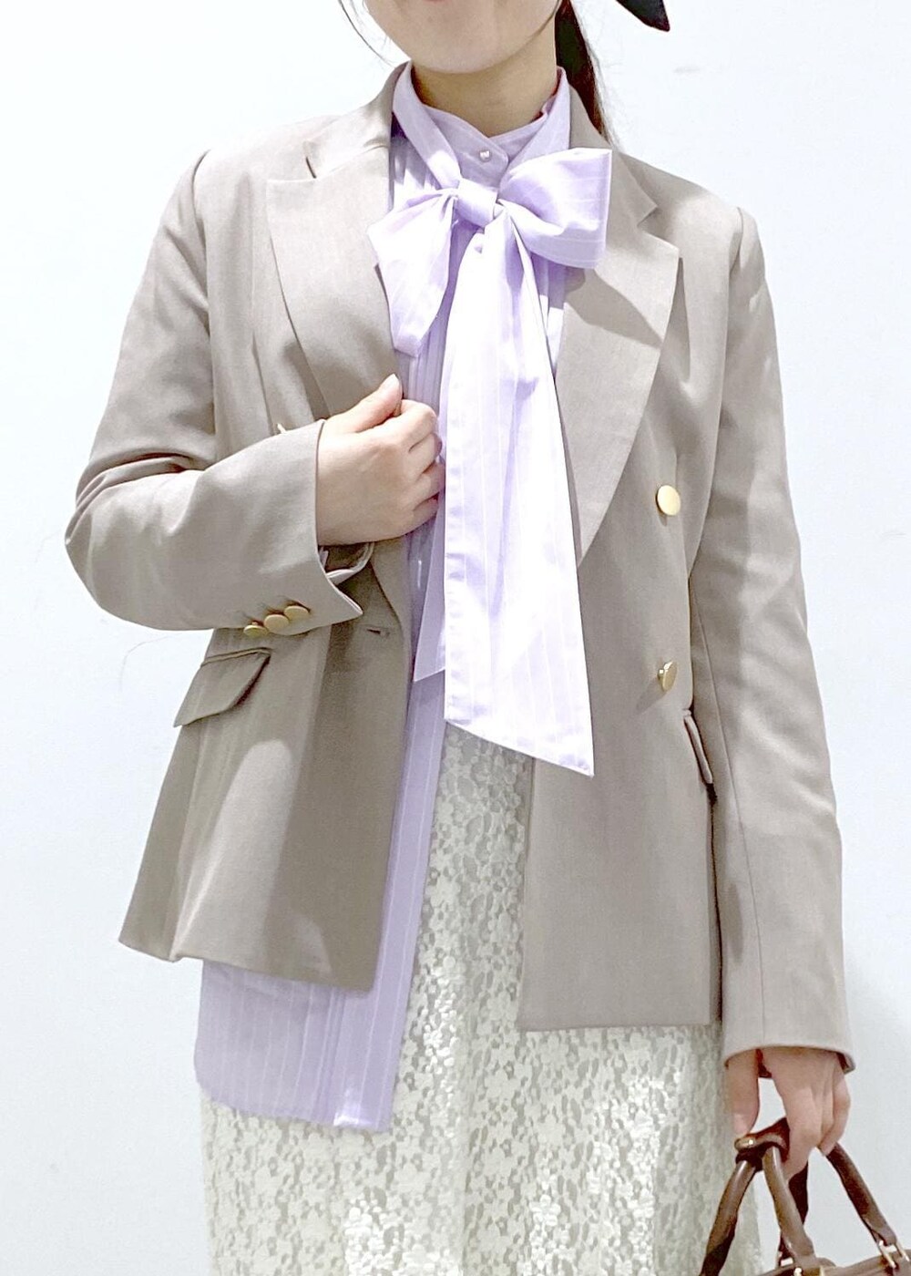 イエロー系のローファー、ブラウン系のボストンバッグ、ベージュ系のテーラードジャケットを着用したレディースの冬コーディネートの9枚目の写真