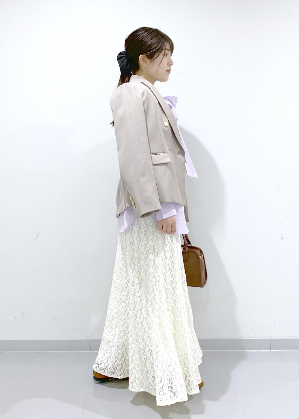 イエロー系のローファー、ブラウン系のボストンバッグ、ベージュ系のテーラードジャケットを着用したレディースの冬コーディネートの6枚目の写真