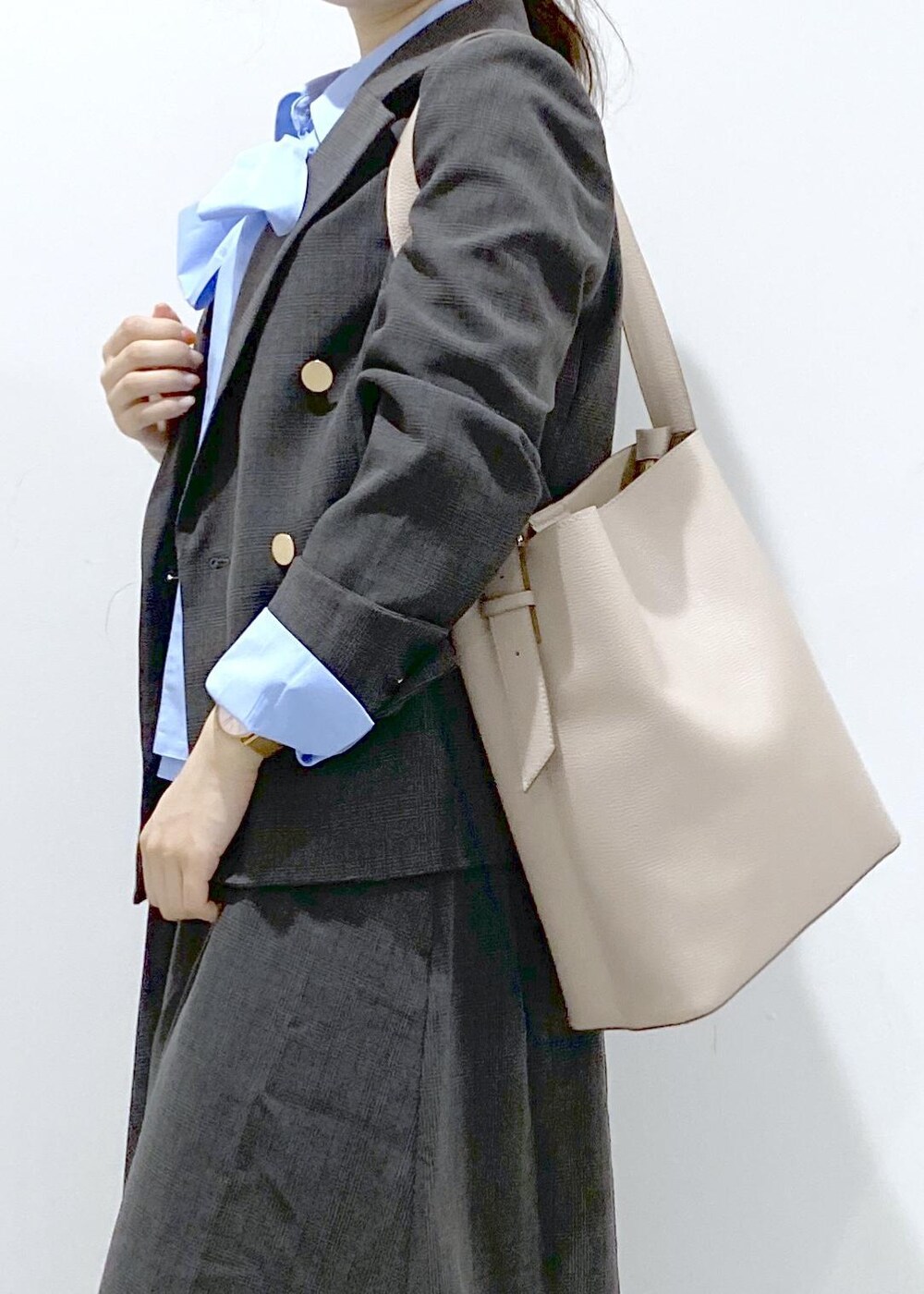 ベージュ系のショルダーバッグ、ブラック系のジャンパースカート、ブラック系のテーラードジャケットを着用したレディースの秋コーディネートの10枚目の写真