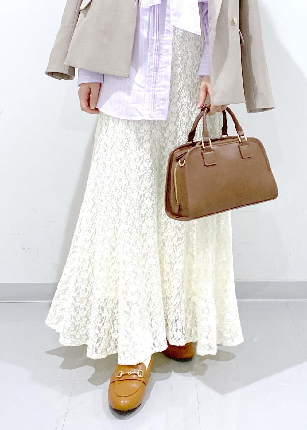 イエロー系のローファー、ブラウン系のボストンバッグ、ベージュ系のテーラードジャケットを着用したレディースの冬コーディネートの10枚目の写真