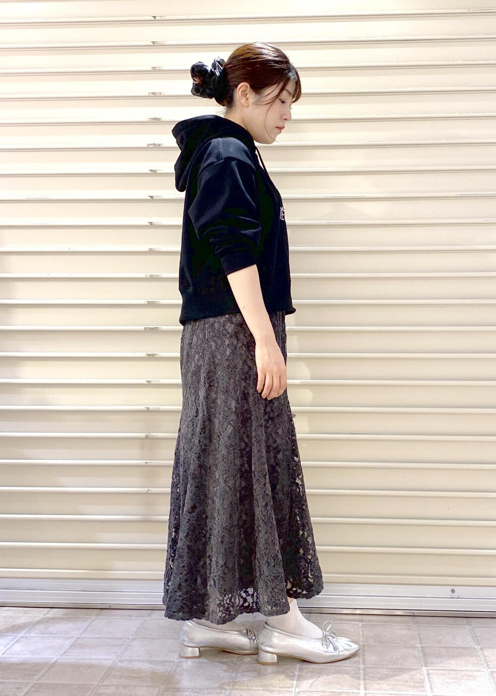 シルバー系のパンプス、ブラック系のパーカー、グレー系のスカートを着用したレディースの秋コーディネートの6枚目の写真