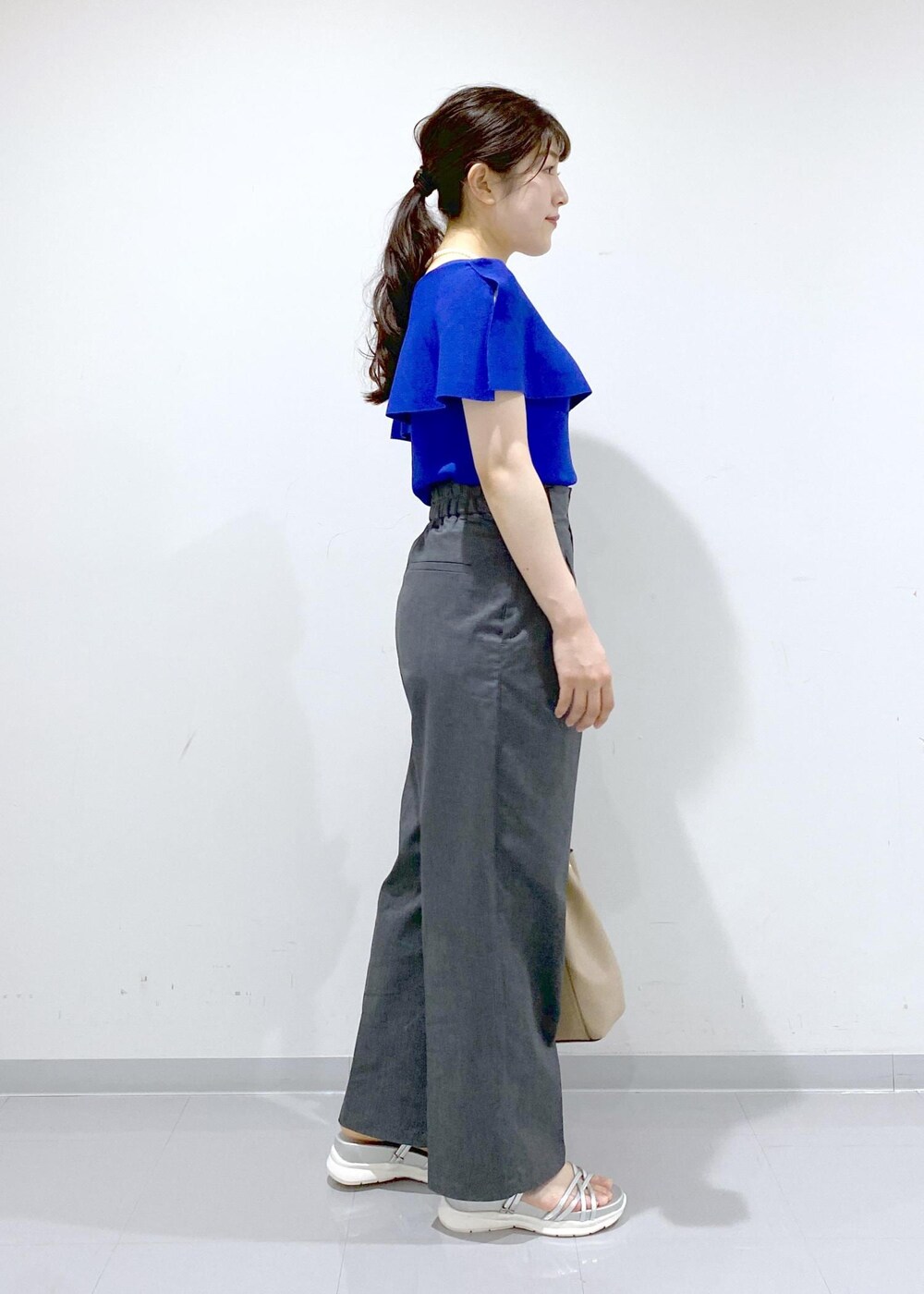 ベージュ系のショルダーバッグ、シルバー系のサンダル、グレー系のチノパンツを着用したレディースの夏コーディネートの7枚目の写真