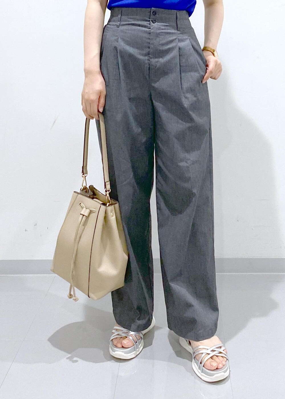 ベージュ系のショルダーバッグ、シルバー系のサンダル、グレー系のチノパンツを着用したレディースの夏コーディネートの10枚目の写真