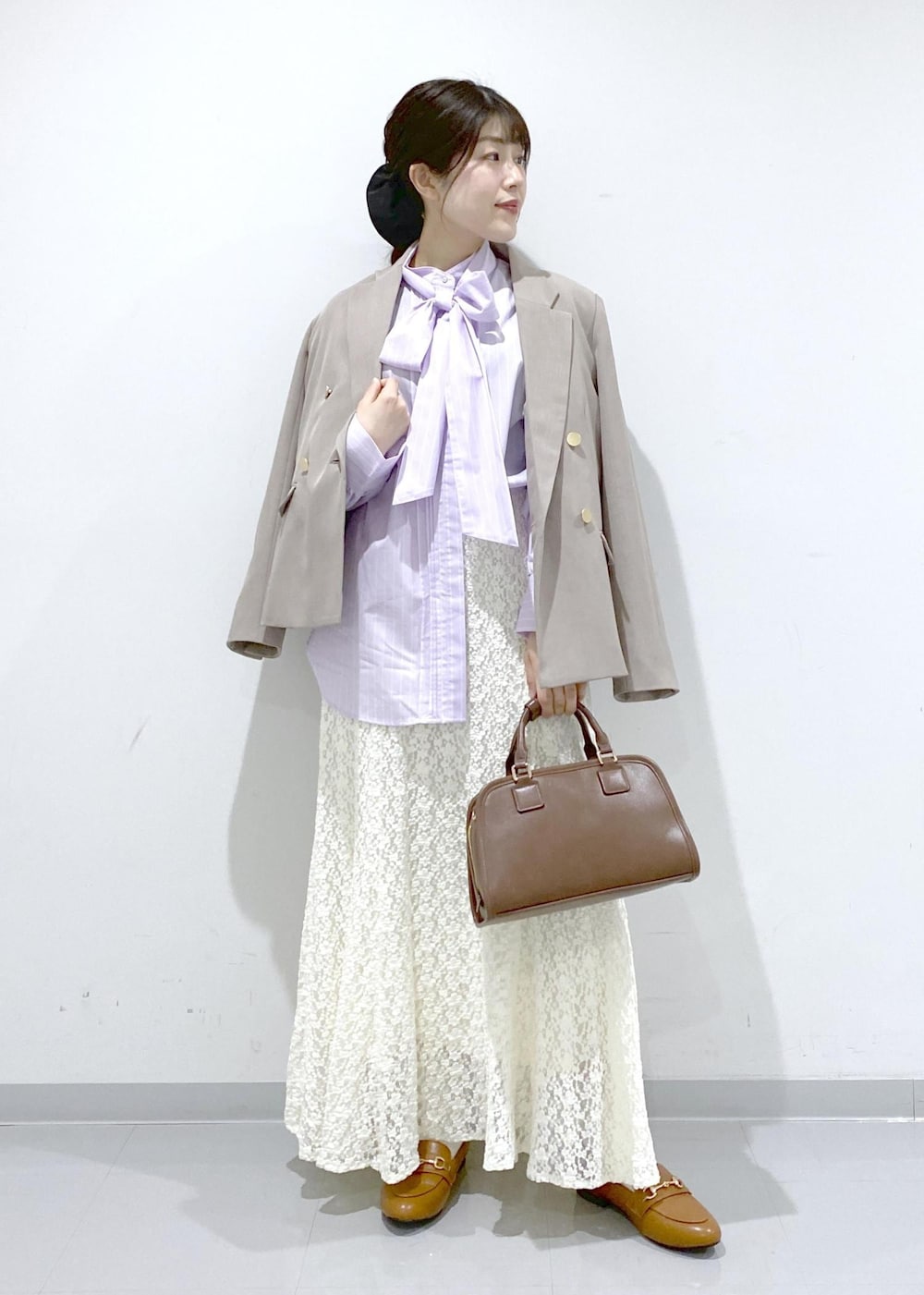 イエロー系のローファー、ブラウン系のボストンバッグ、ベージュ系のテーラードジャケットを着用したレディースの冬コーディネートの7枚目の写真