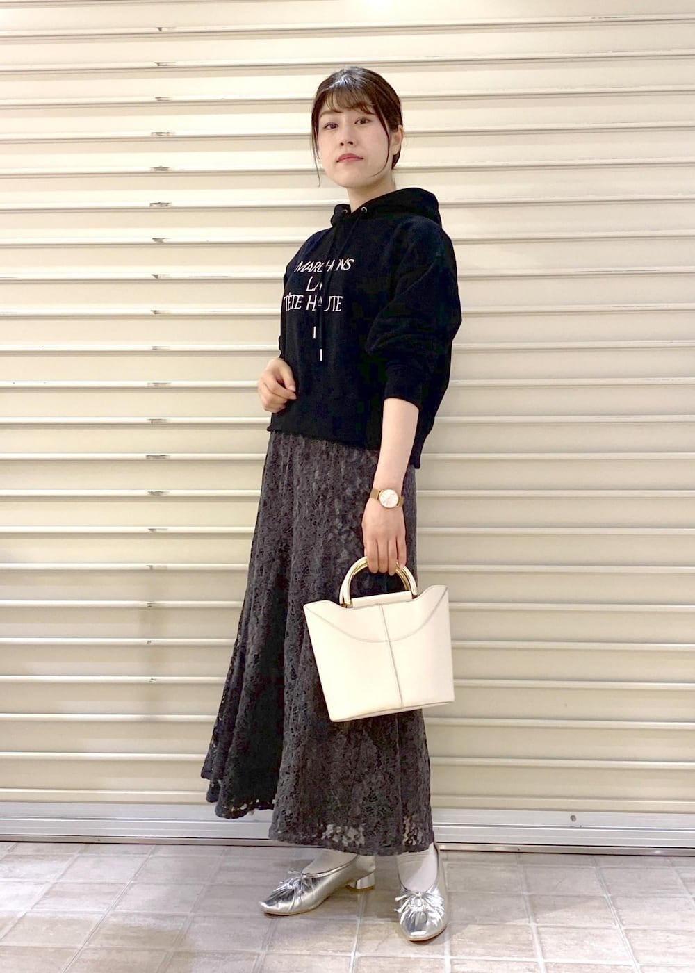 シルバー系のパンプス、ブラック系のパーカー、グレー系のスカートを着用したレディースの秋コーディネートの3枚目の写真