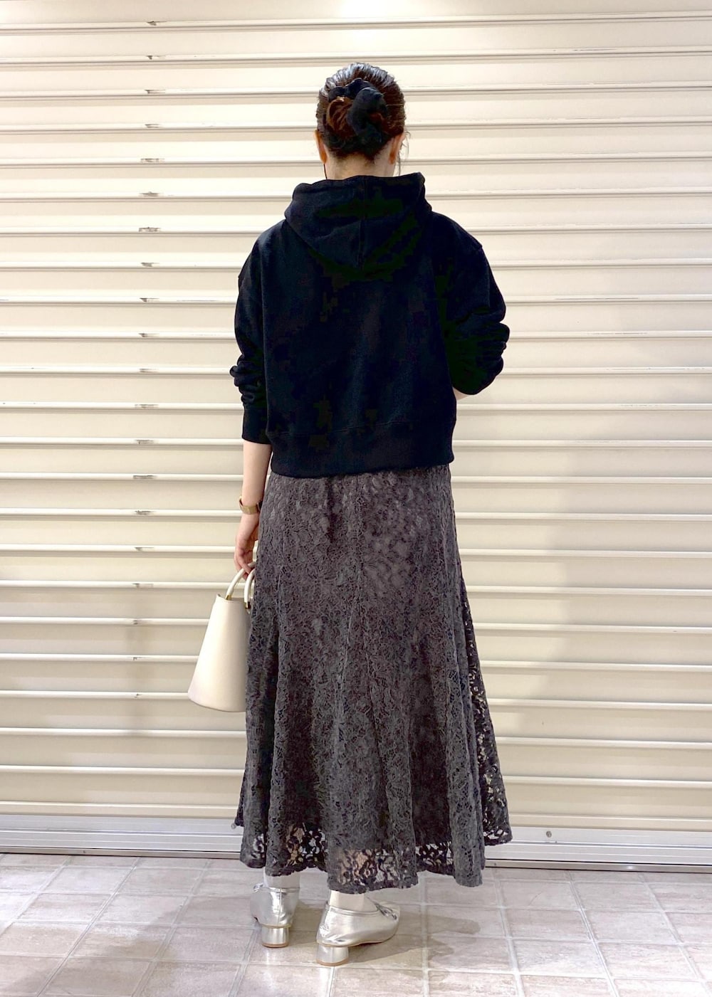 シルバー系のパンプス、ブラック系のパーカー、グレー系のスカートを着用したレディースの秋コーディネートの5枚目の写真