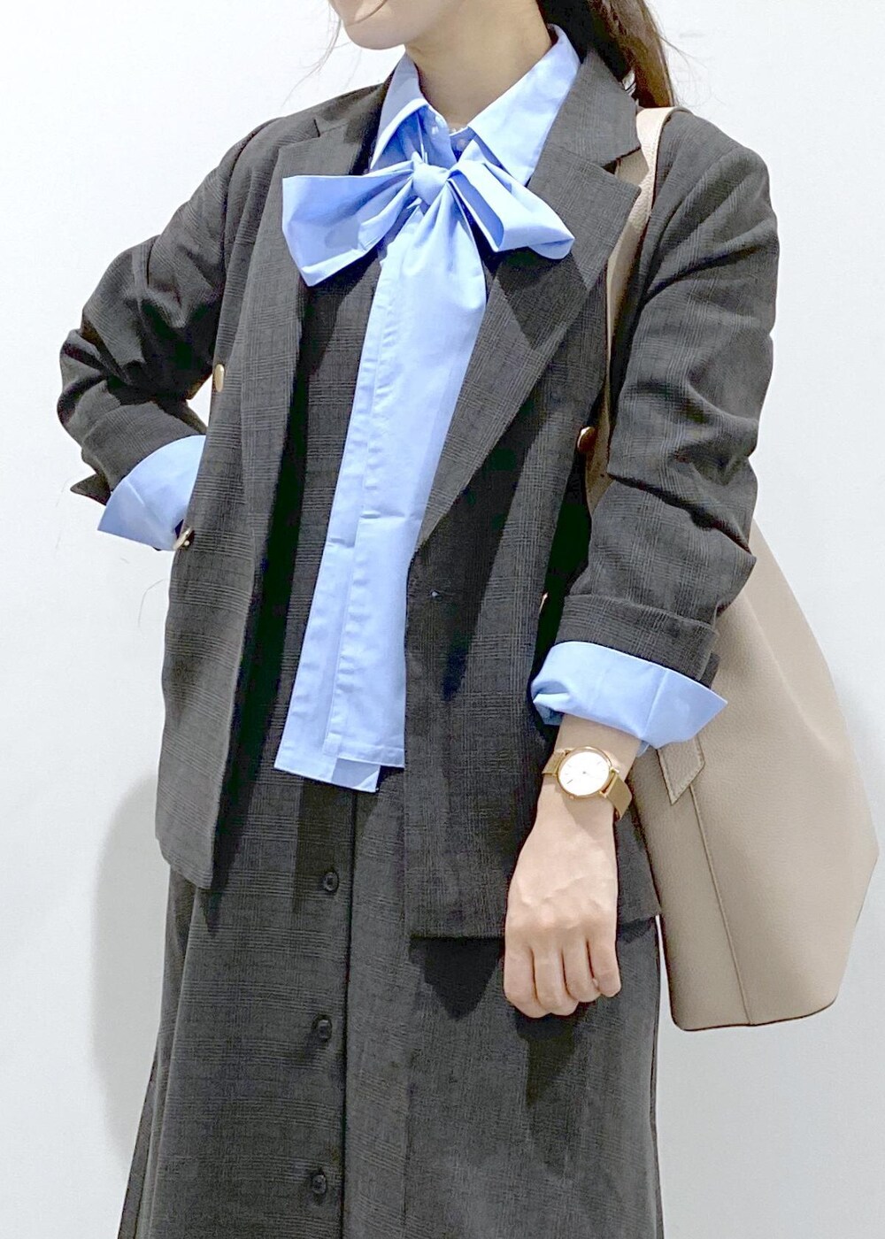 ベージュ系のショルダーバッグ、ブラック系のジャンパースカート、ブラック系のテーラードジャケットを着用したレディースの秋コーディネートの9枚目の写真