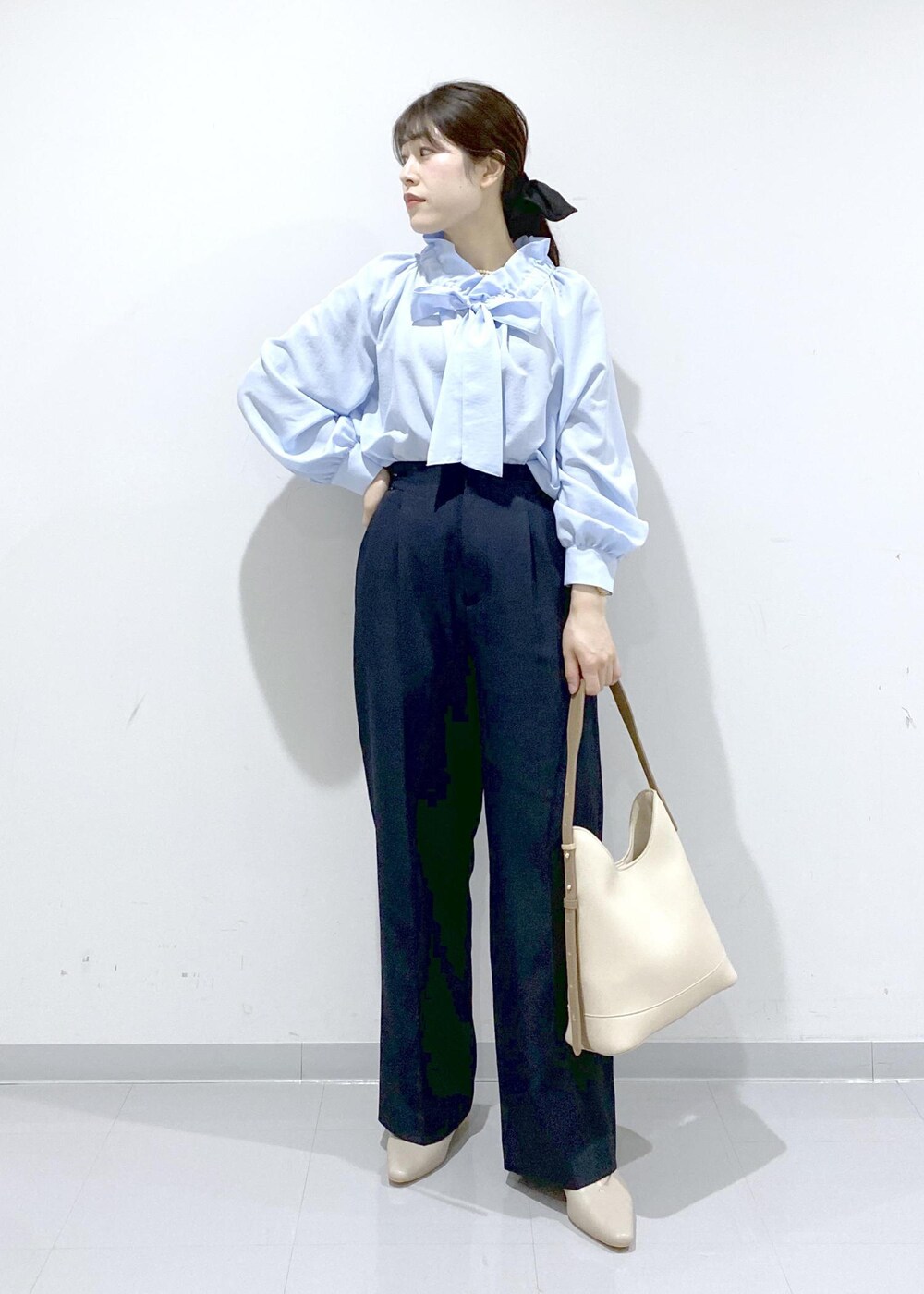 ベージュ系のパンプス、ホワイト系のショルダーバッグ、ブルー系のシャツ/ブラウスを着用したレディースの冬コーディネートの4枚目の写真