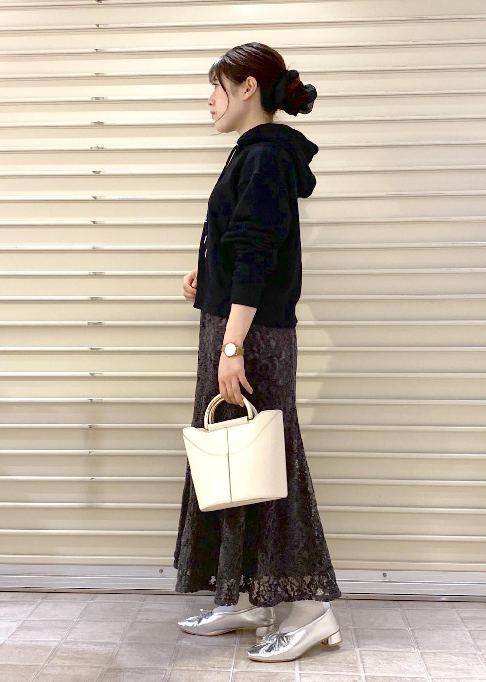 シルバー系のパンプス、ブラック系のパーカー、グレー系のスカートを着用したレディースの秋コーディネートの4枚目の写真