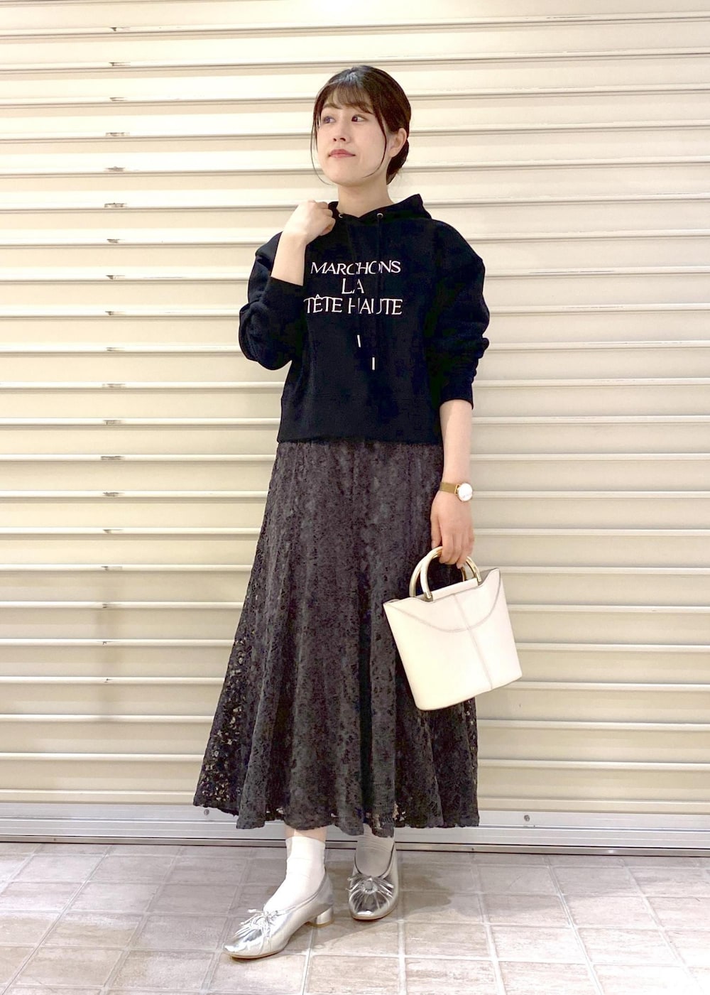 シルバー系のパンプス、ブラック系のパーカー、グレー系のスカートを着用したレディースの秋コーディネートの2枚目の写真