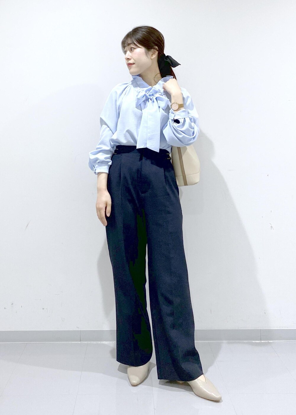ベージュ系のパンプス、ホワイト系のショルダーバッグ、ブルー系のシャツ/ブラウスを着用したレディースの冬コーディネートの2枚目の写真