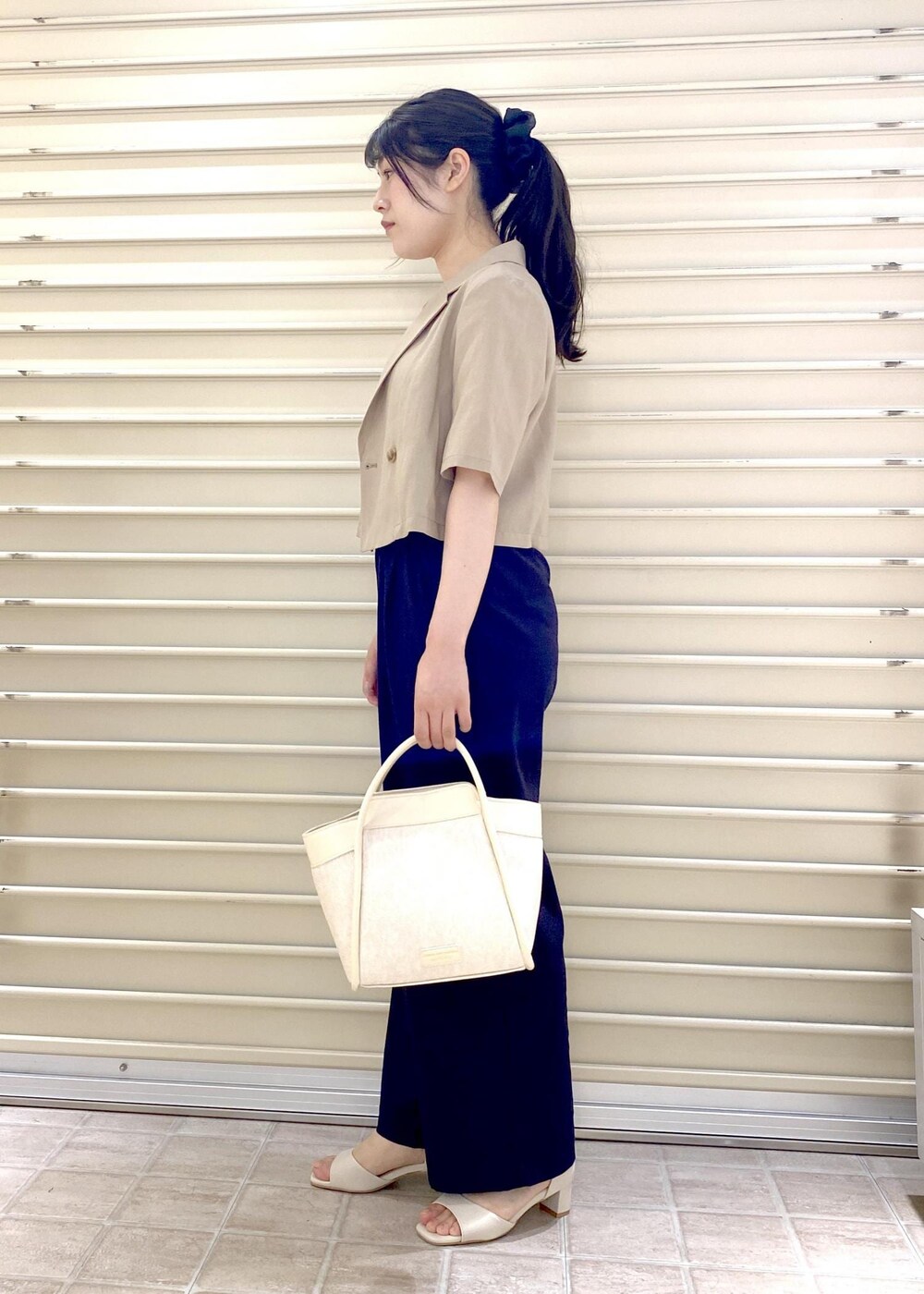 ホワイト系のサンダル、ピンク系のTシャツ/カットソー、ベージュ系のテーラードジャケットを着用したレディースの春コーディネートの2枚目の写真