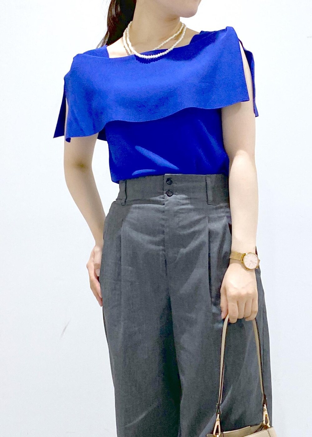 ベージュ系のショルダーバッグ、シルバー系のサンダル、グレー系のチノパンツを着用したレディースの夏コーディネートの9枚目の写真