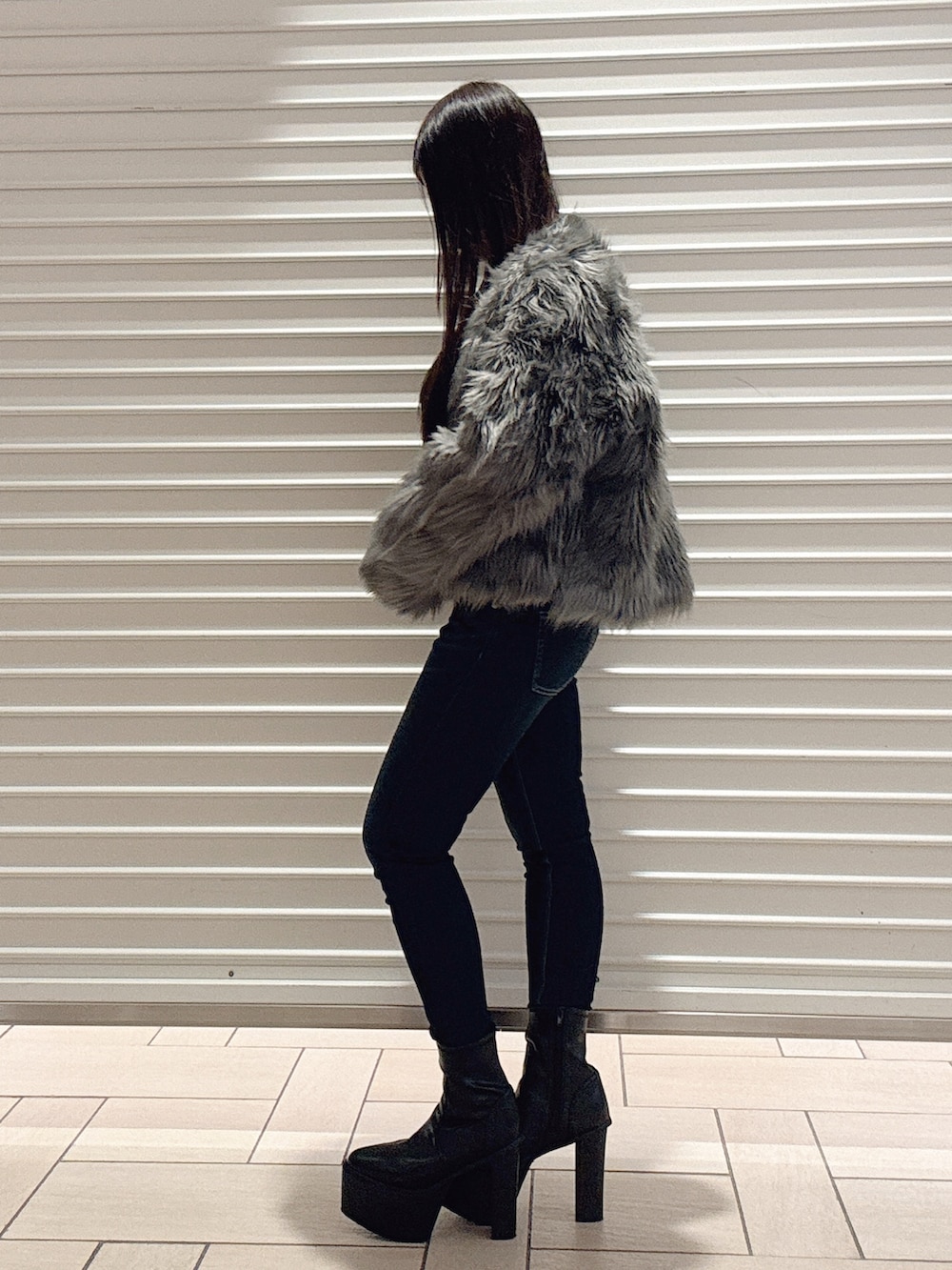 ブラック系のニット/セーター、グレー系のライダースジャケット、ブルー系のデニムパンツを着用したレディースの秋コーディネートの3枚目の写真