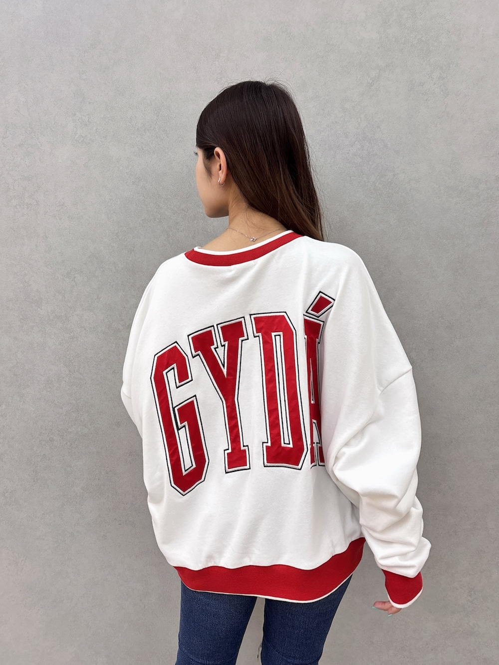 ホワイト系のスウェット、ブルー系のデニムパンツ、ブラック系のサンダルを着用したレディースの夏コーディネートの5枚目の写真