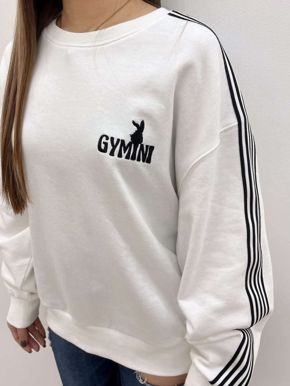 ホワイト系のスウェット、ブルー系のデニムパンツ、ブラック系のブーツを着用したレディースの冬コーディネートの6枚目の写真