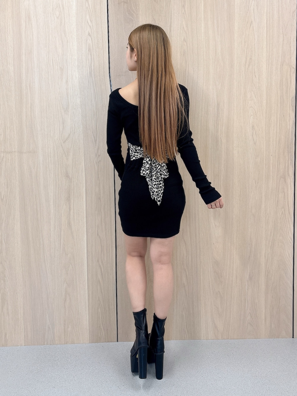 ブラック系のワンピース、ブラック系のブーツを着用したレディースの春コーディネートの3枚目の写真