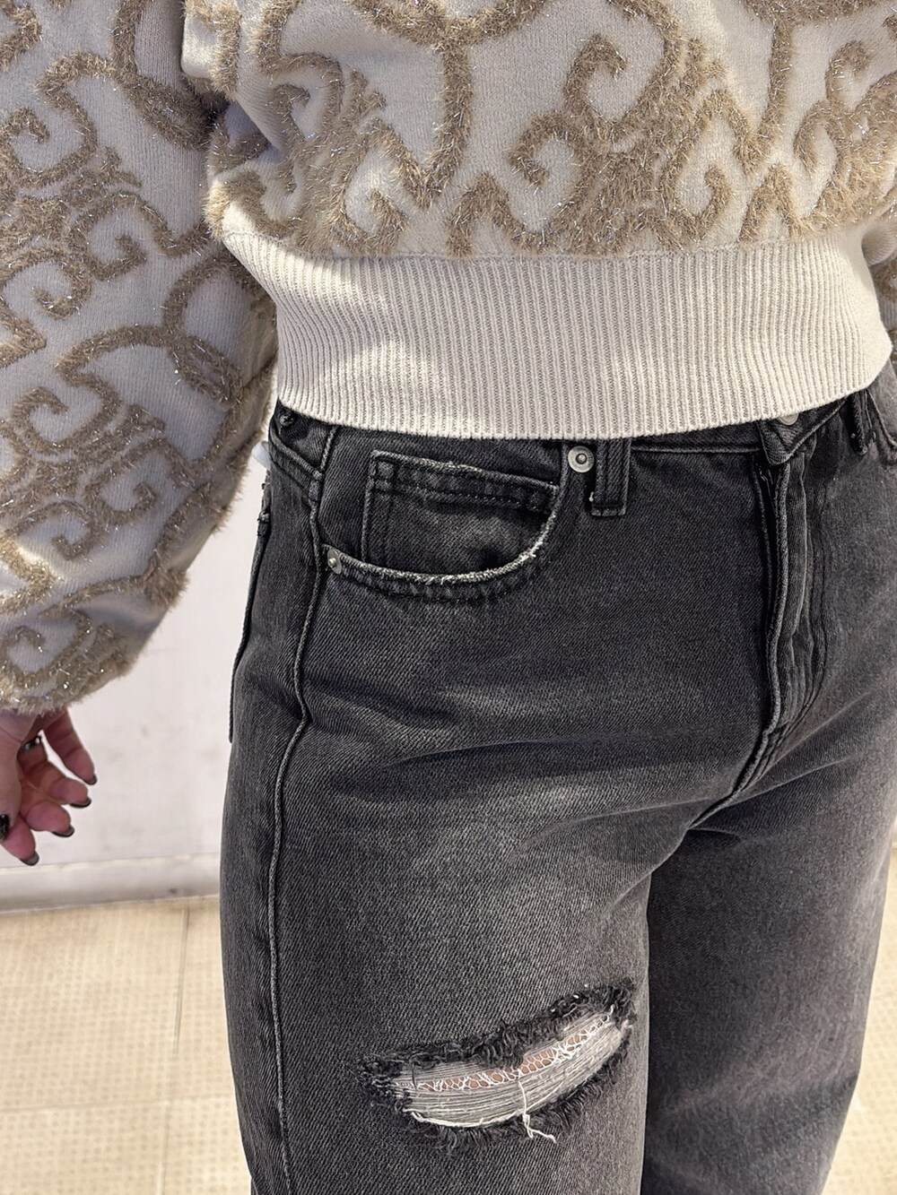 ホワイト系のニット/セーター、ブラック系のデニムパンツ、ブラック系のブーツを着用したレディースの秋コーディネートの4枚目の写真