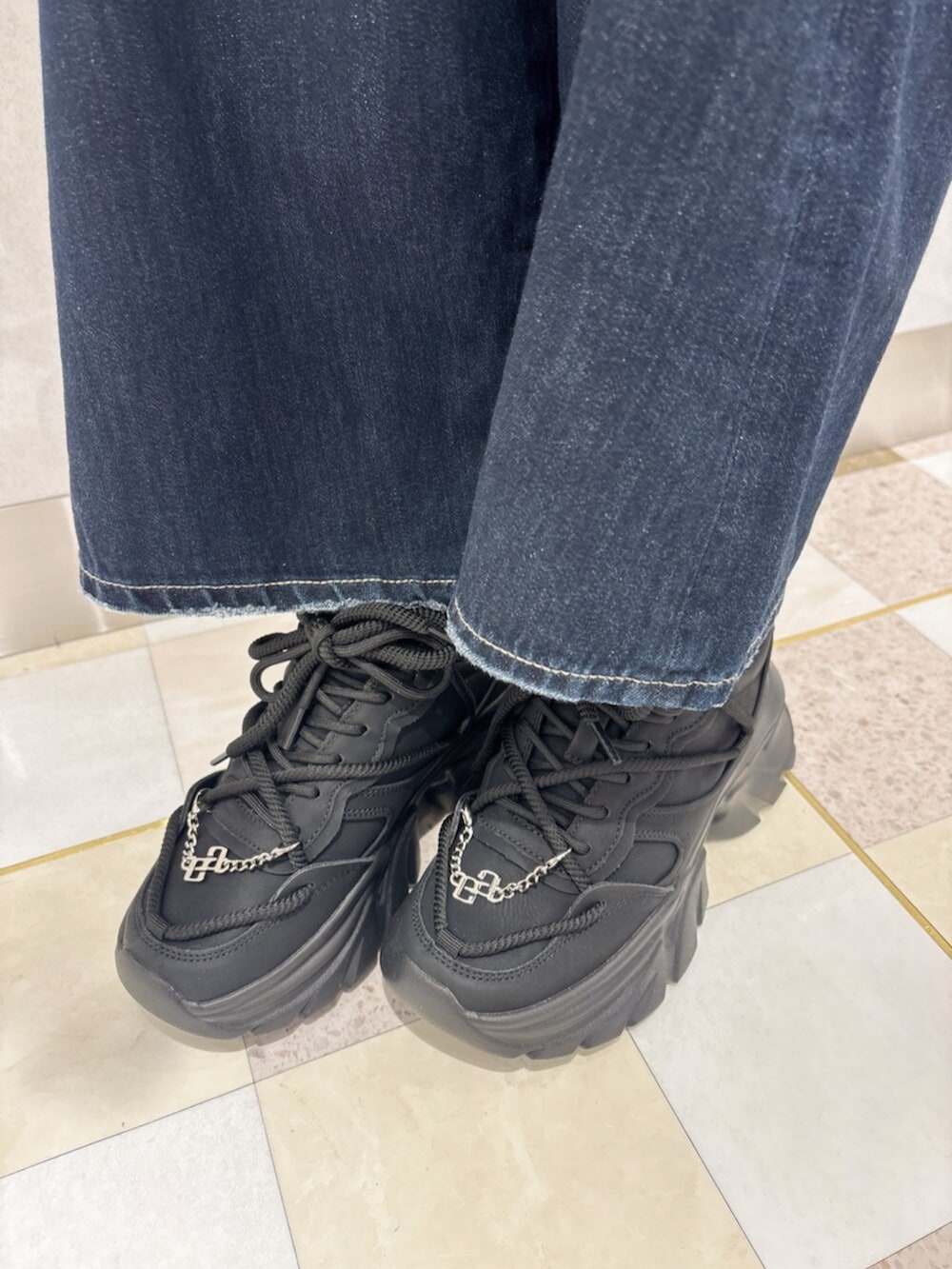 ブルー系のデニムパンツ、ブラック系のスニーカー、ブラック系のTシャツ/カットソーを着用したレディースの秋コーディネートの7枚目の写真