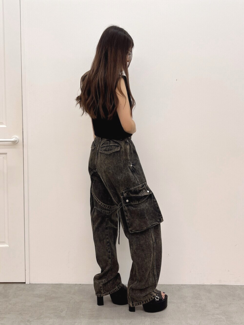 ブラック系のパーカー、ブルー系のデニムパンツ、ブラック系のサンダルを着用したレディースの夏コーディネートの2枚目の写真