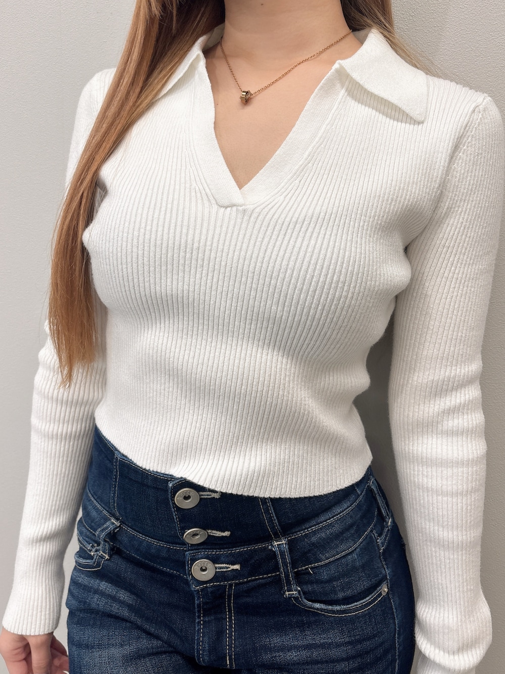 ホワイト系のニット/セーター、ブルー系のデニムパンツ、ブラック系のブーツを着用したレディースの春コーディネートの5枚目の写真