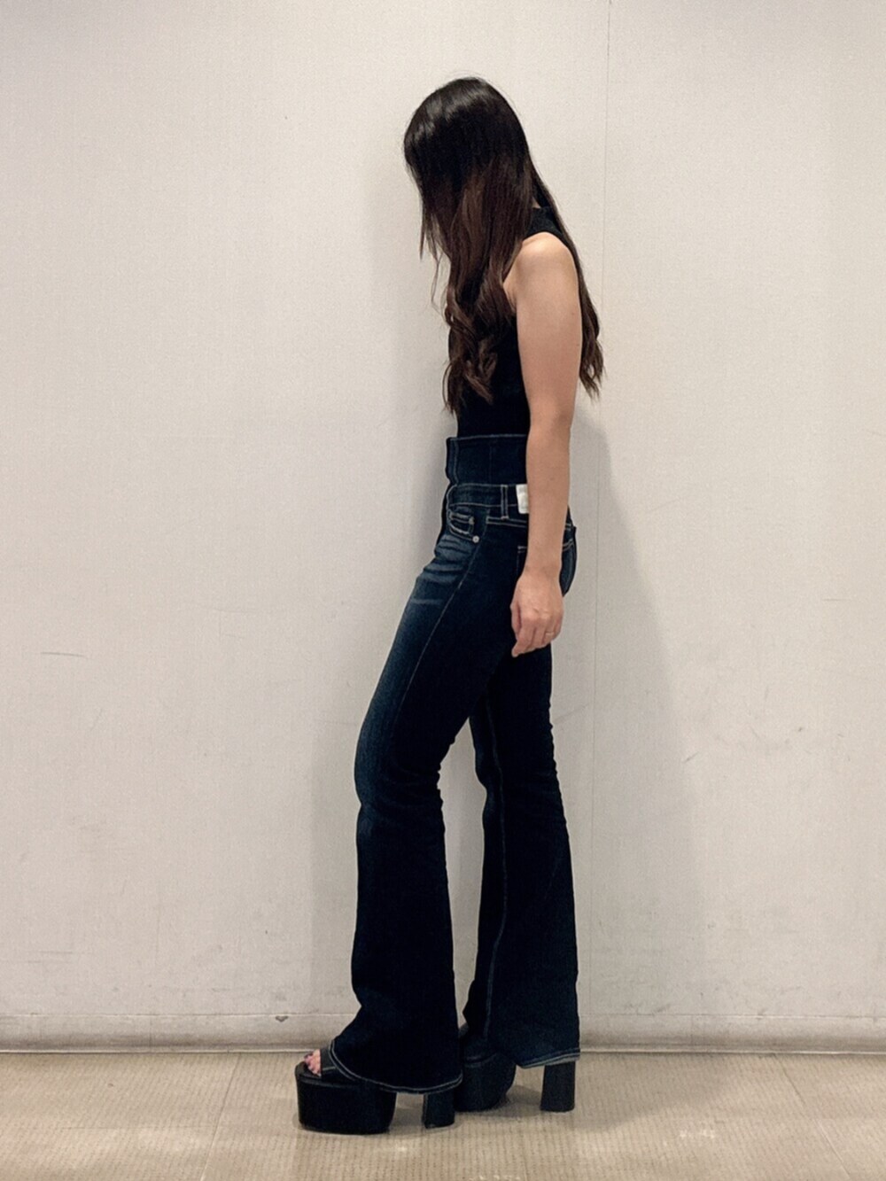 ブラック系のサンダル、ブラック系のニット/セーター、ブルー系のデニムパンツを着用したレディースの夏コーディネートの2枚目の写真