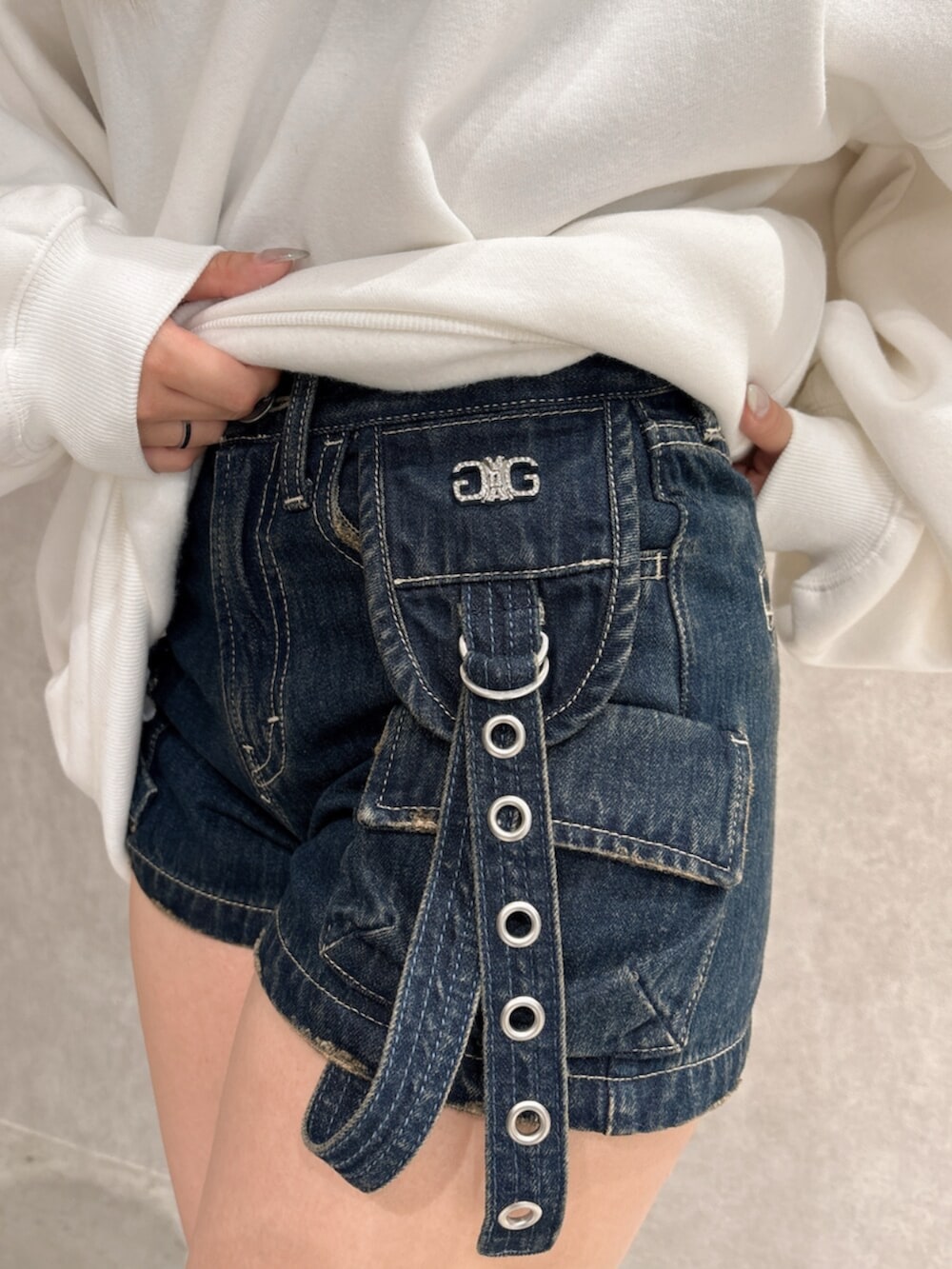 ホワイト系のスウェット、ブルー系のデニムパンツ、ブラック系のブーツを着用したレディースの秋コーディネートの7枚目の写真