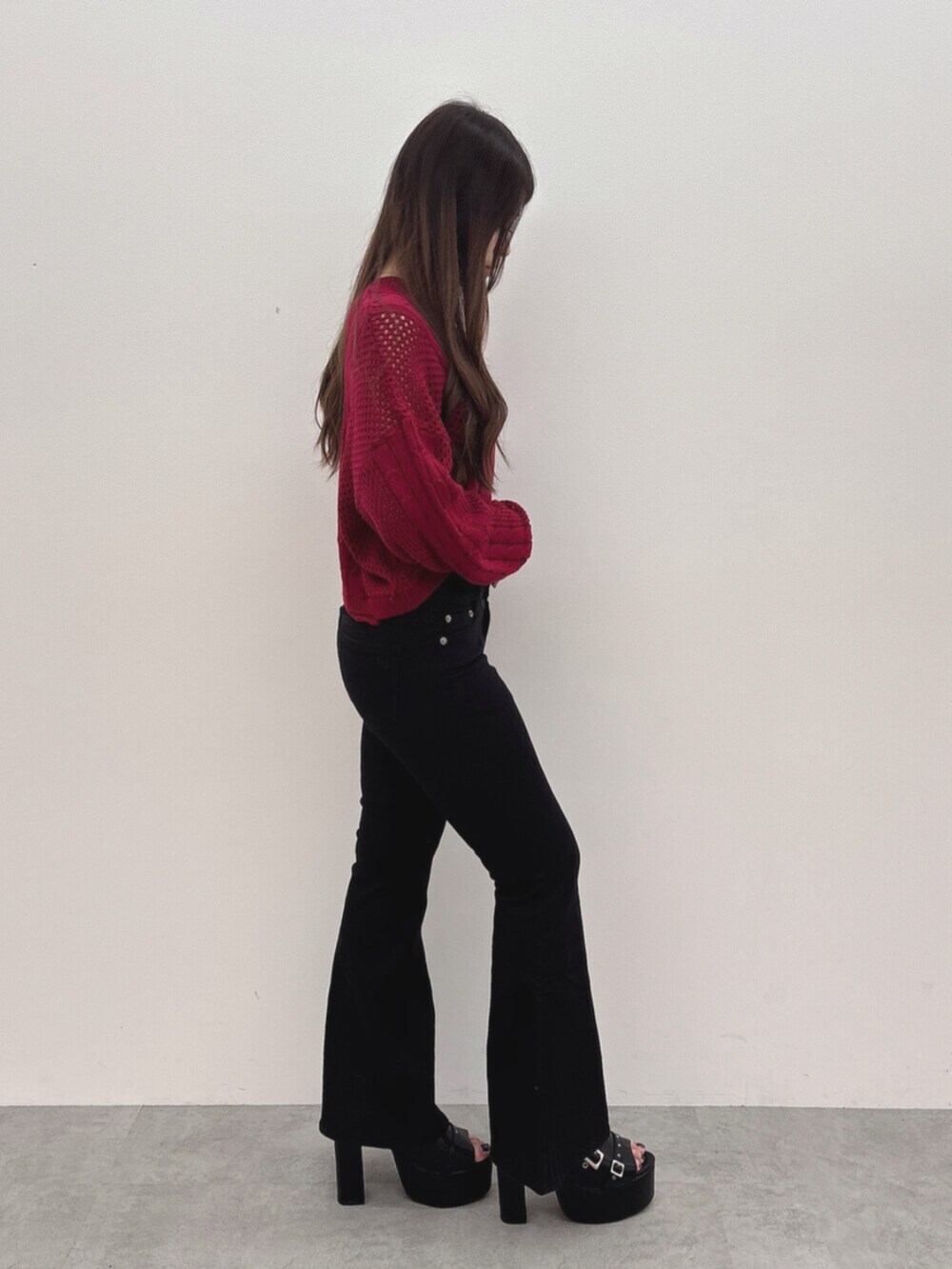 ブラック系のサンダル、レッド系のニット/セーター、ブラック系のデニムパンツを着用したレディースの夏コーディネートの2枚目の写真